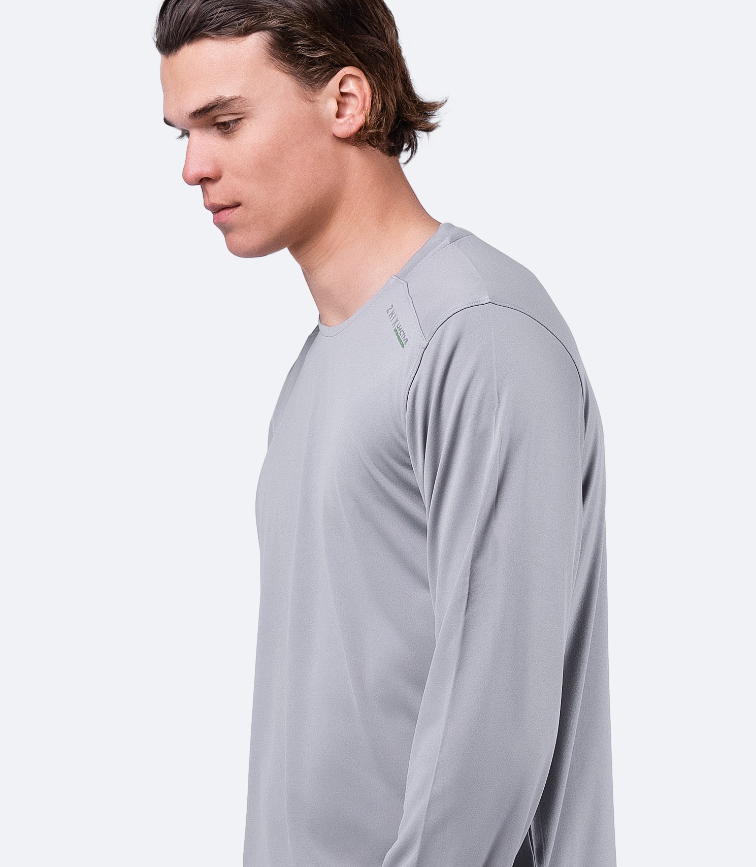 Side angle of Zhik Men's UVactive Long Sleeve Top in grey, showing tapered arms and Velcro®-resistant fabric.