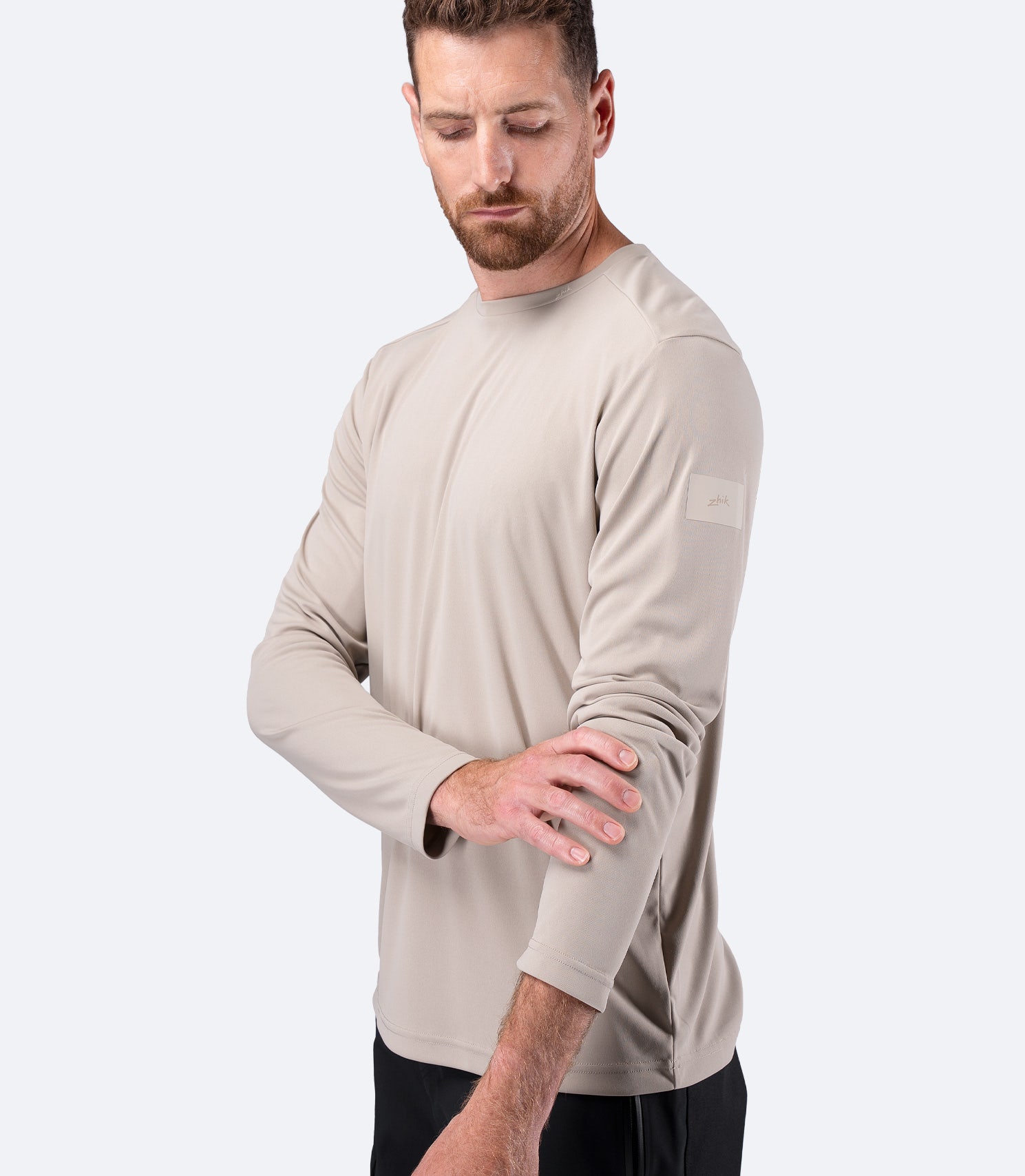 Zhik Men's UVActive Long Sleeve Tech Top in Stone, side view pulling sleeve to show flexible cuff