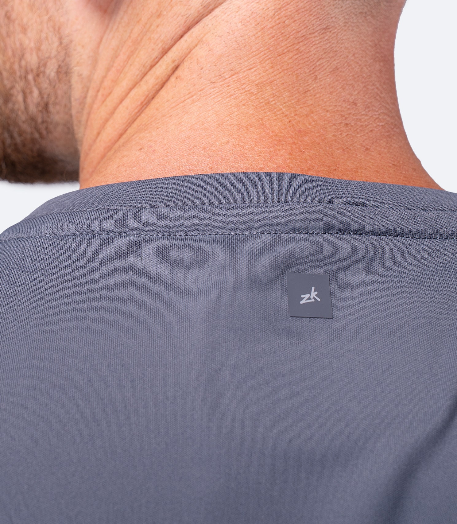 Back shoulder blade close-up of Zhik Men's UVActive Tech Tee in Slate with subtle back logo