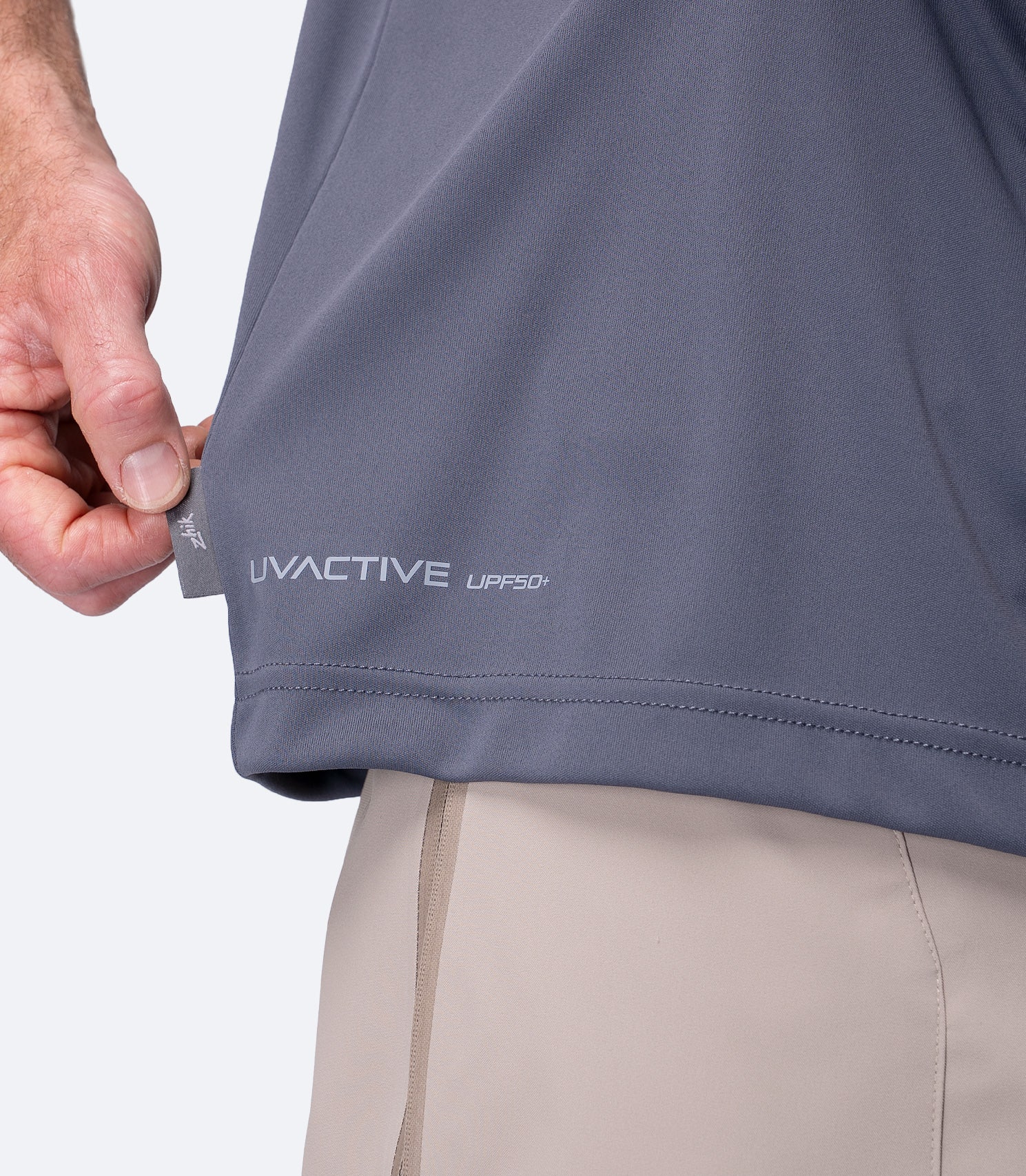Close-up of UVACTIVE UPF 50+ logo and subtle Zhik tag at waist on Slate Men's Tech Tee