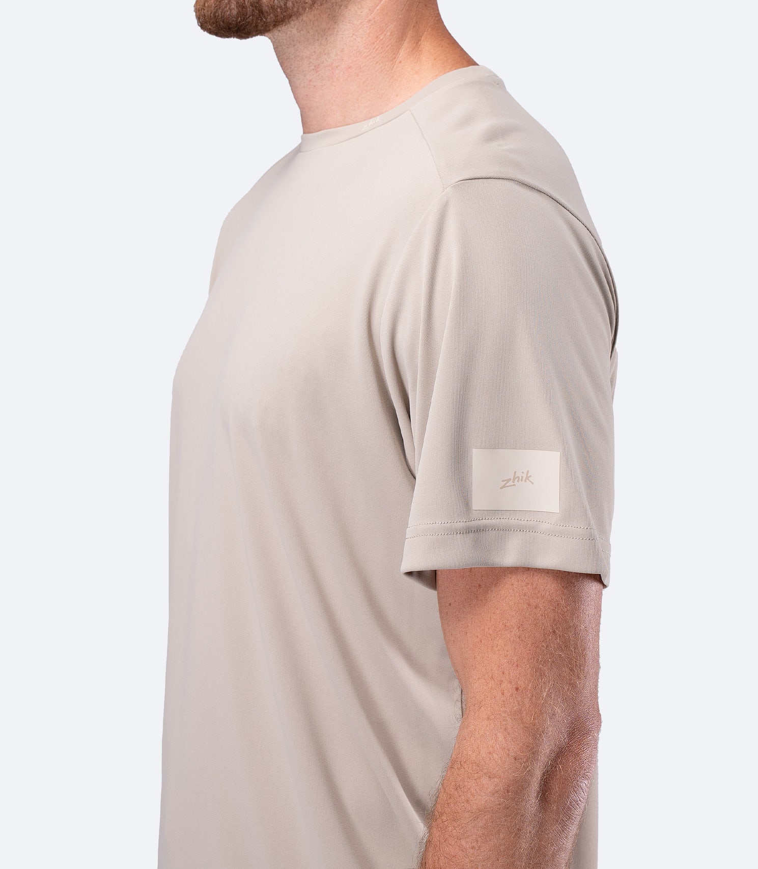 Close-up of Zhik shoulder logo on Men's UVActive Short Sleeve Tech Tee in Stone