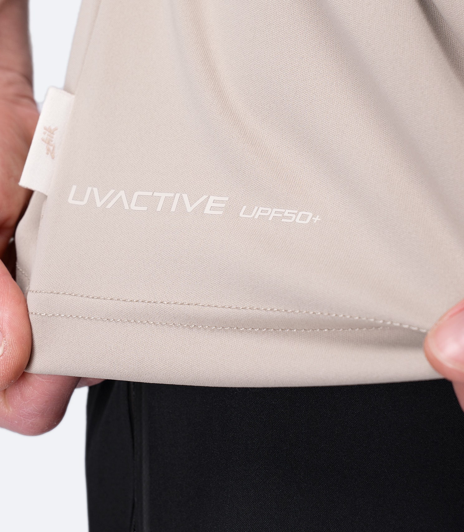 Close-up of UVACTIVE UPF 50+ logo and small Zhik tag at waist on Stone Men's Tech Tee