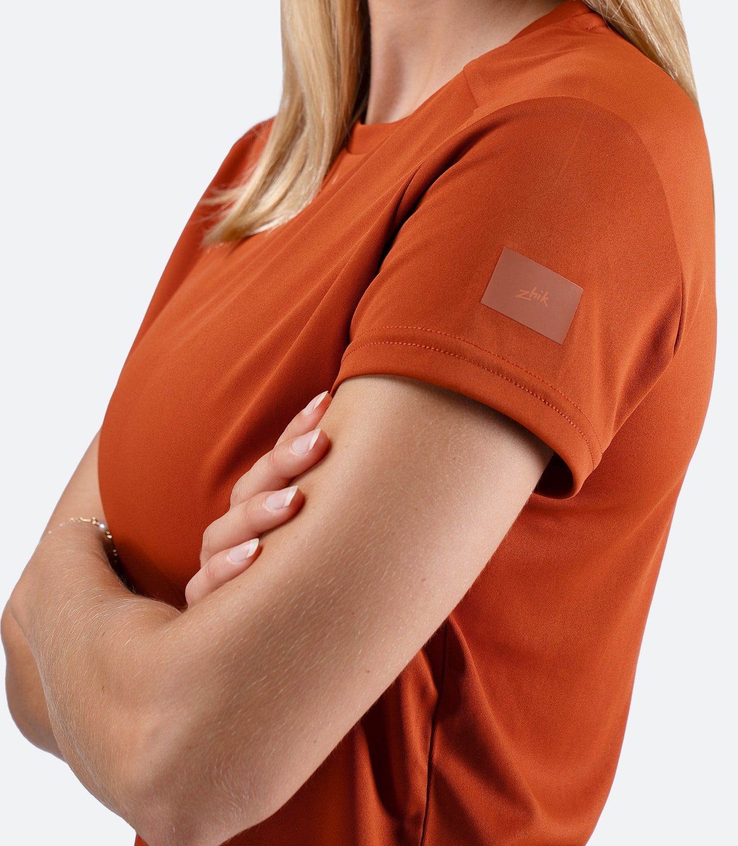 Closeup of shoulder Zhik logo on Women's UVActive short sleeve tech tee in Red Earth