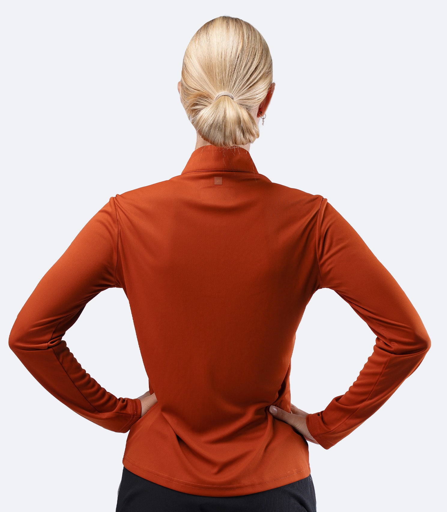 Rear view of Zhik Women's UVActive 1/4 Zip Tech Top in Red Earth, showing clean back panel and fit