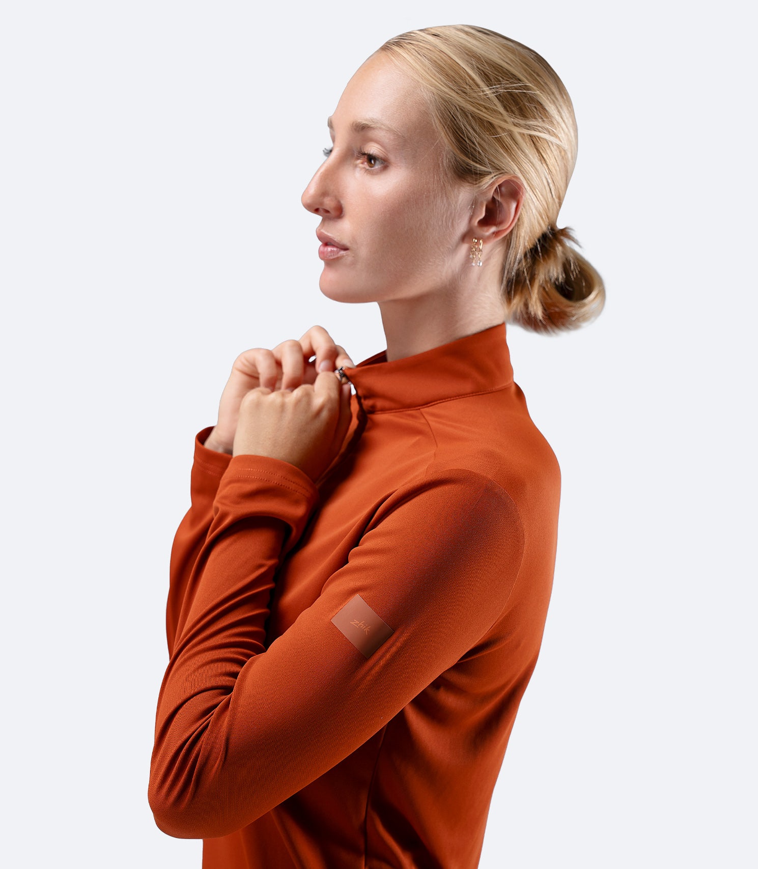 Side view of Red Earth Zhik Women's UVActive 1/4 Zip Top, hand on zip highlighting adjustable venting