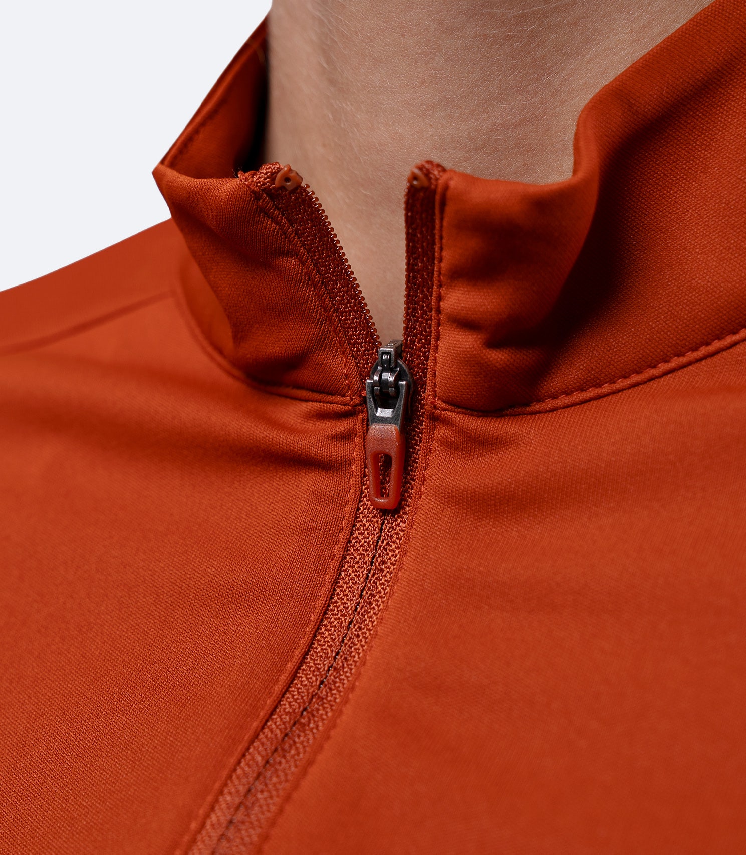 Close-up of quarter zipper on Zhik Women's UVActive Tech Top in Red Earth, showing smooth finish