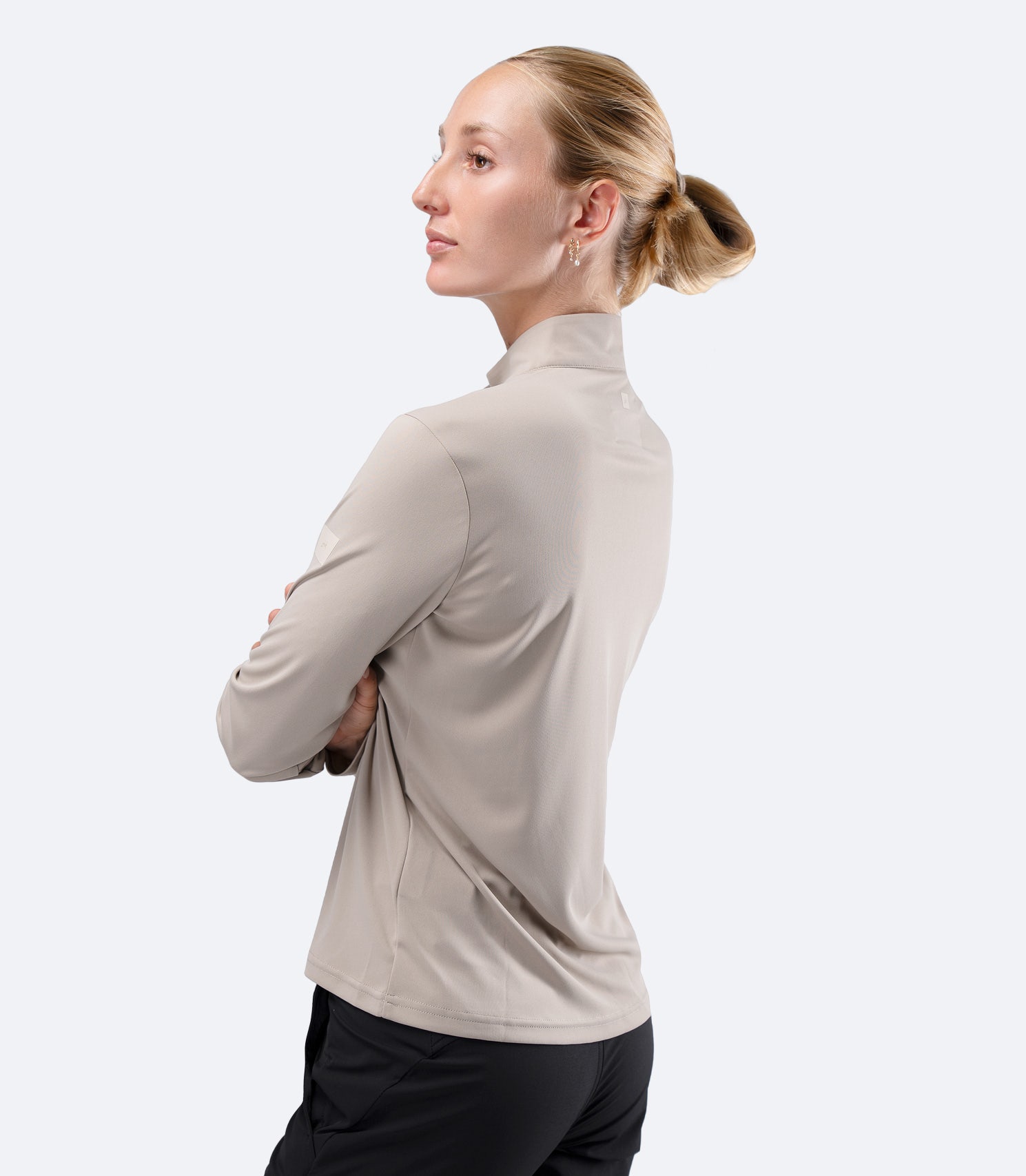 Side profile of Stone Zhik Women's UVActive Top, one hand on hip highlighting regular active fit