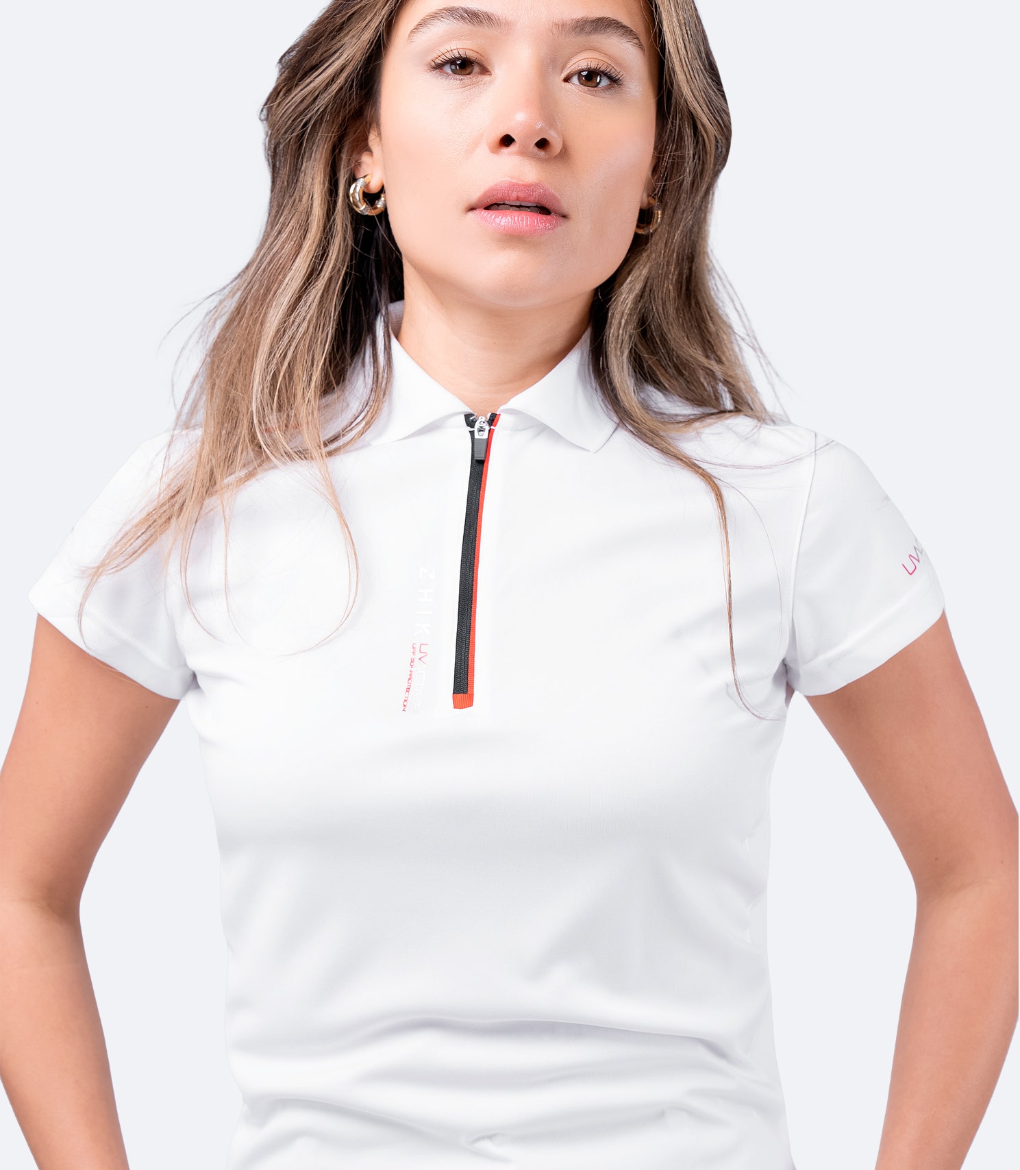 Close-up of white Zhik Women's UVactive Polo, showing high-gauge knit fabric, collar detail, and moisture-wicking technology.
