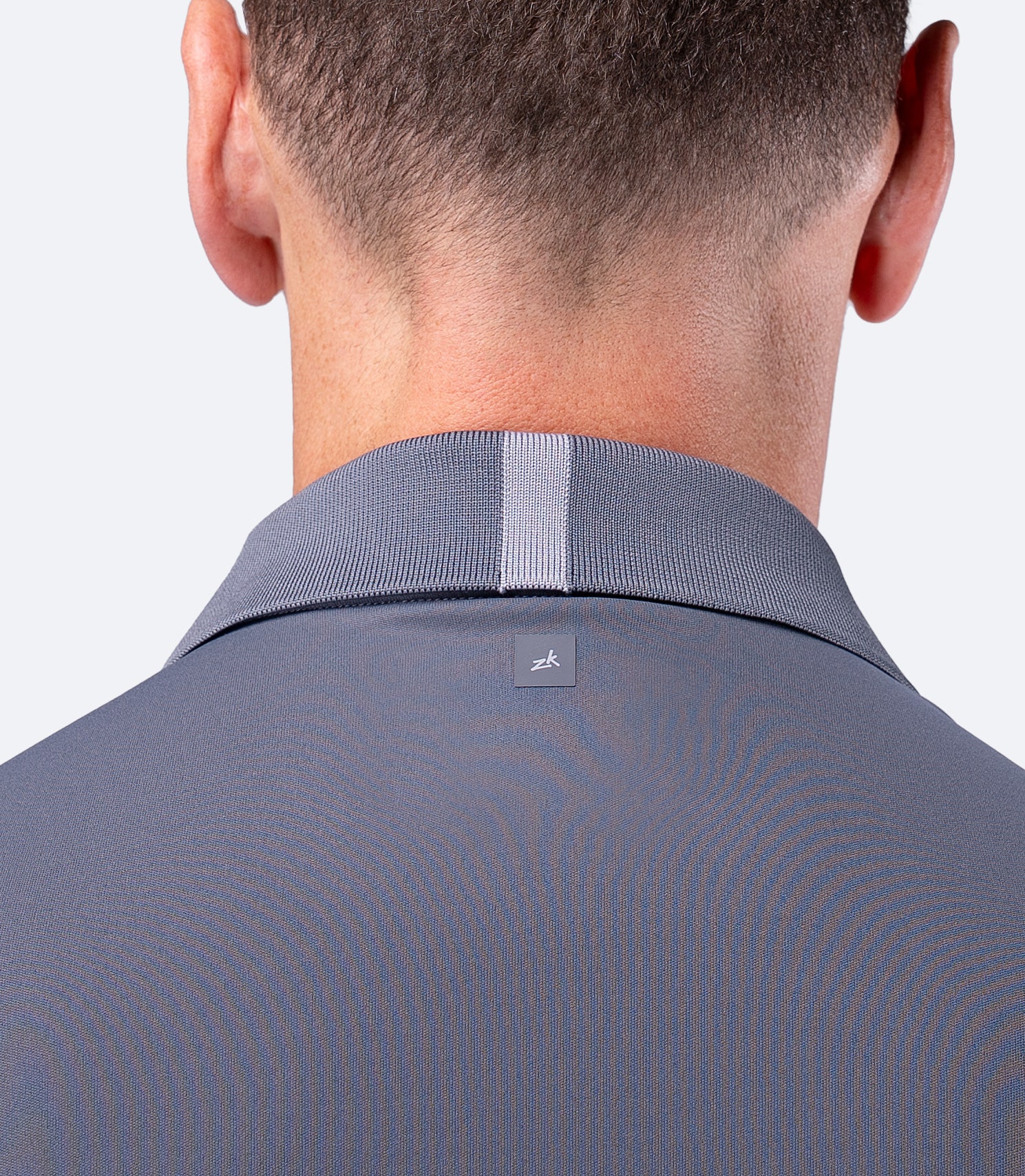 Back view close up of Slate Zhik UVActive Polo, subtle logo at shoulder blades and clean panel