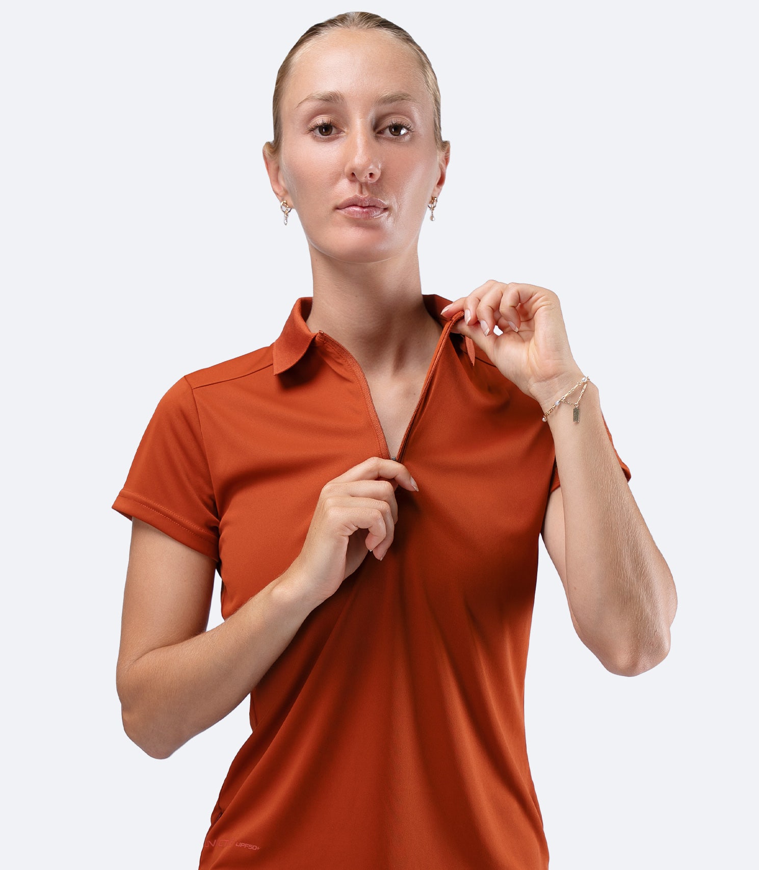 Front view close-up of Zhik UVActive Polo in Red Earth, collar up showing refined sports aesthetic