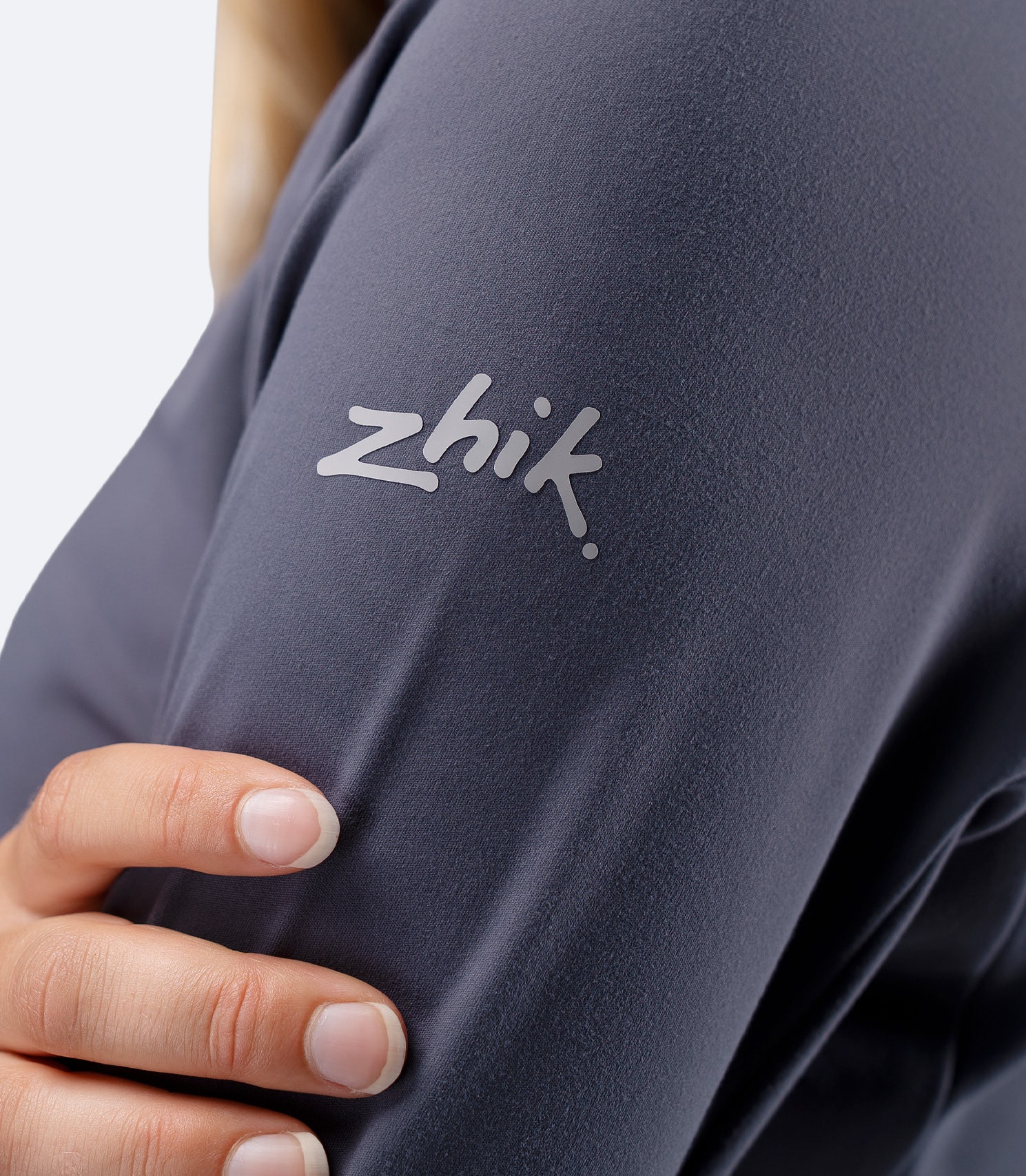 Close up of subtle Zhik logo on shoulder of Women's ZhikMotion 1/4 zip top in Slate