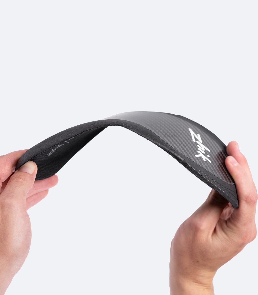 Zhik Hiking X Carbon Insole in black being flexed to show directional Carbitex® Monoflex flexibility for hiking