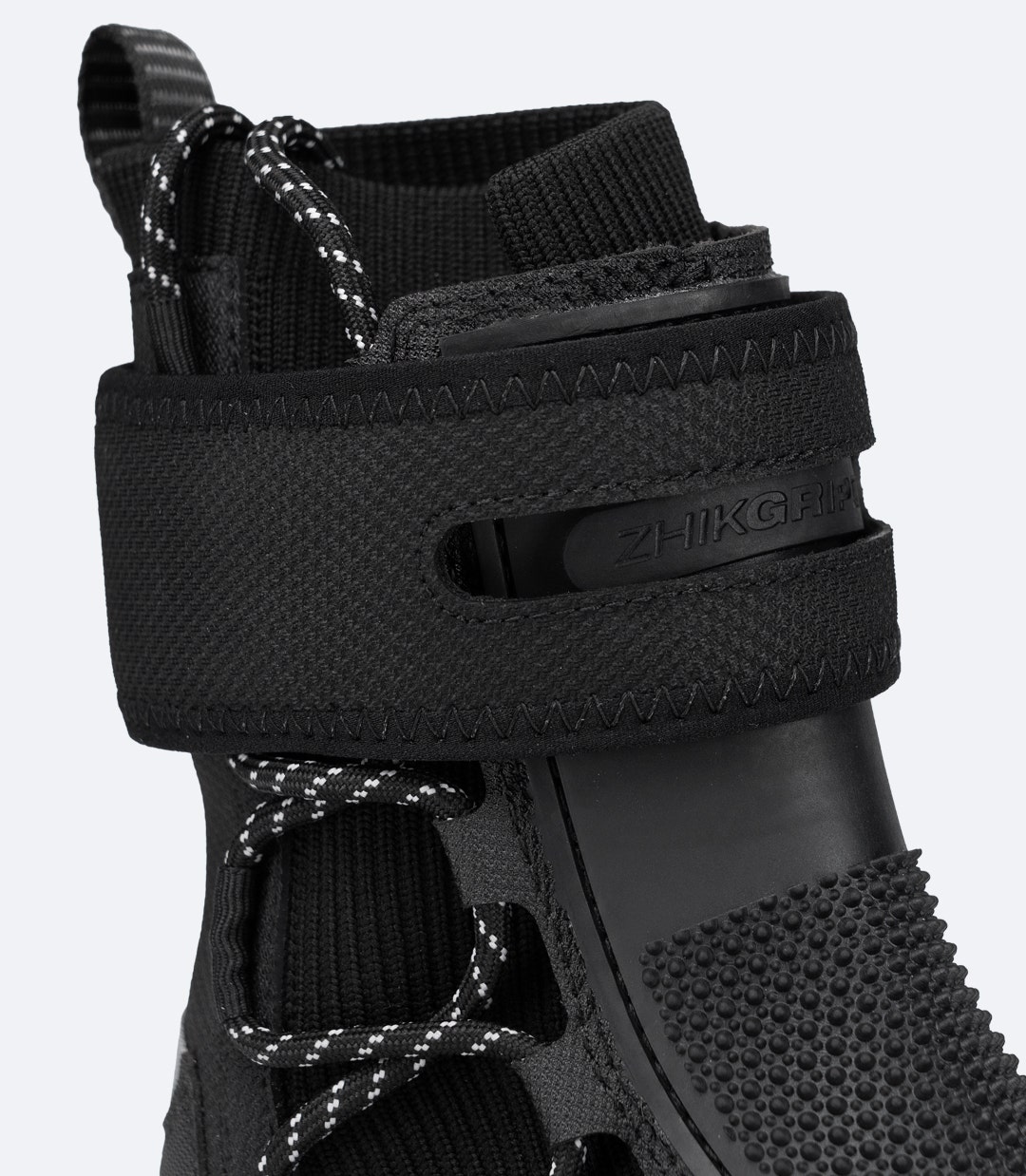 Primo piano del cinturino posteriore in Velcro alla caviglia dello Zhik Hiking X Boot nero con canale antiscivolo e passante sicuro per il tallone