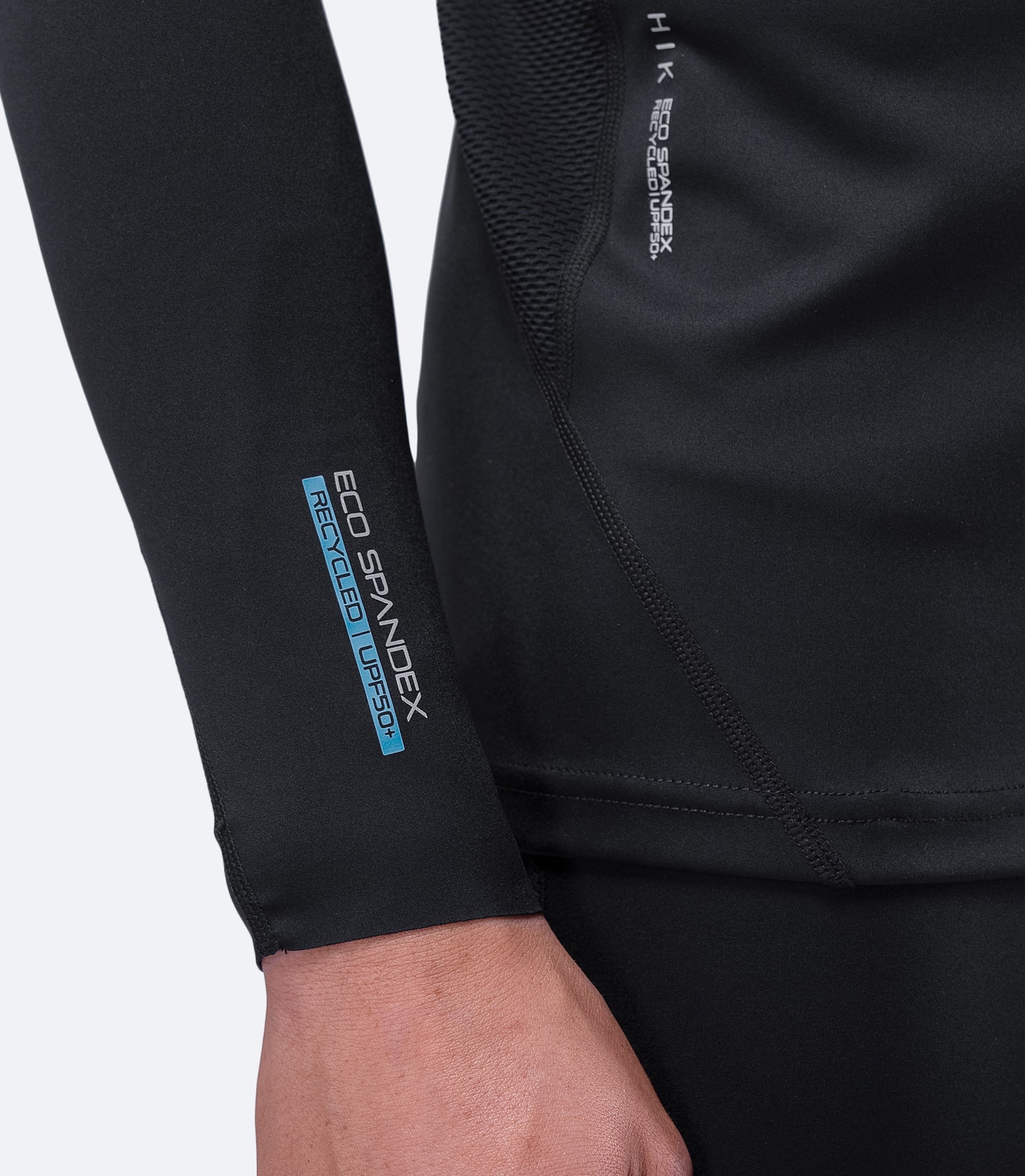 Detailed view of Zhik Men's Black Eco Spandex Top wrist area, showing soft, cooling fabric and bar-tacked seams for durability.