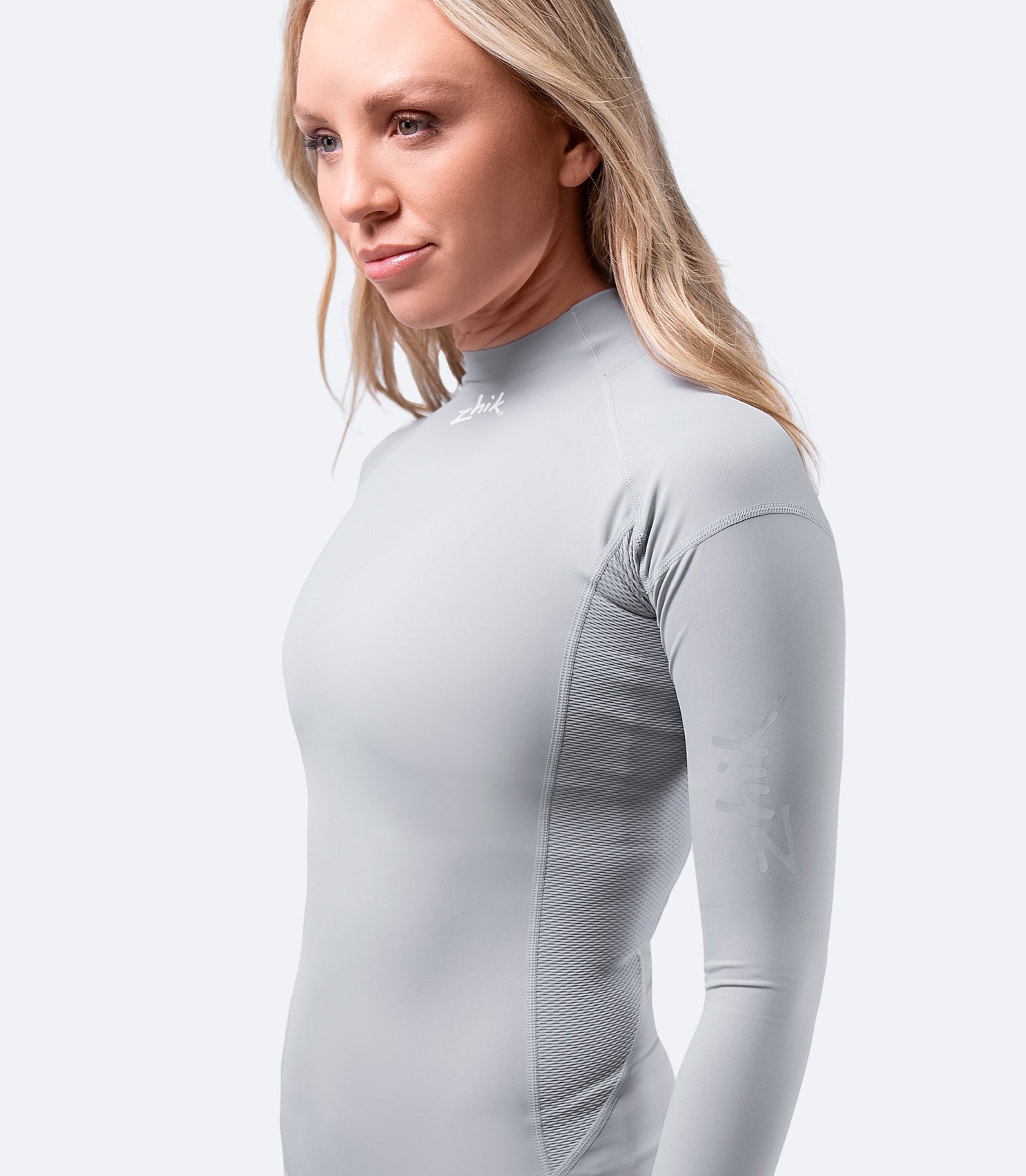 Side view of Zhik Women's Platinum Eco Spandex Long Sleeve Top, showcasing the Zhik logo and the lightweight, flexible 4-way stretch fabric.
