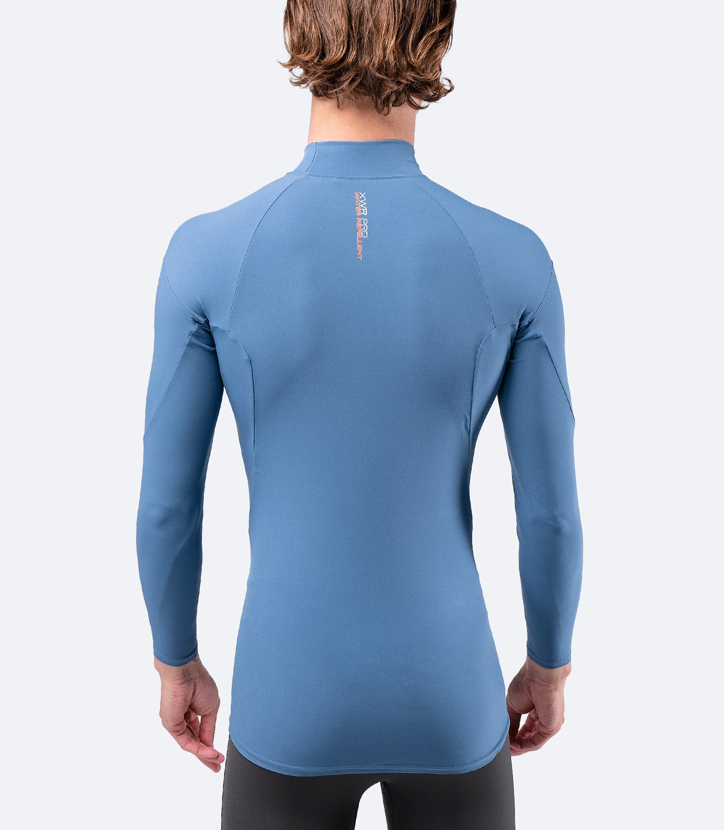 Back view of Zhik Men's XWR Pro Long Sleeve Top in deep blue, highlighting raglan cut and lightweight, quick-drying fabric.