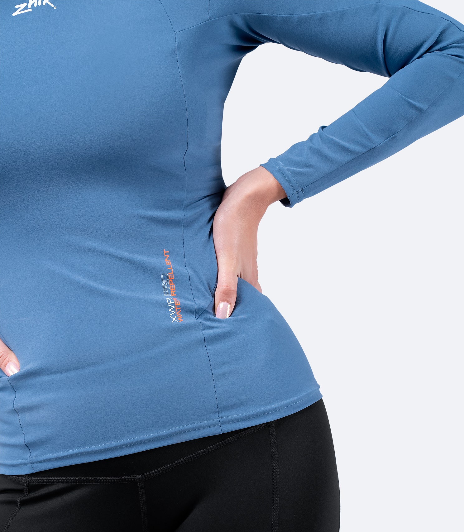 Close-up of Zhik Women's XWR Pro Long Sleeve Top in Deep Blue, showing waistband design and high-stretch woven fabric for flexibility.