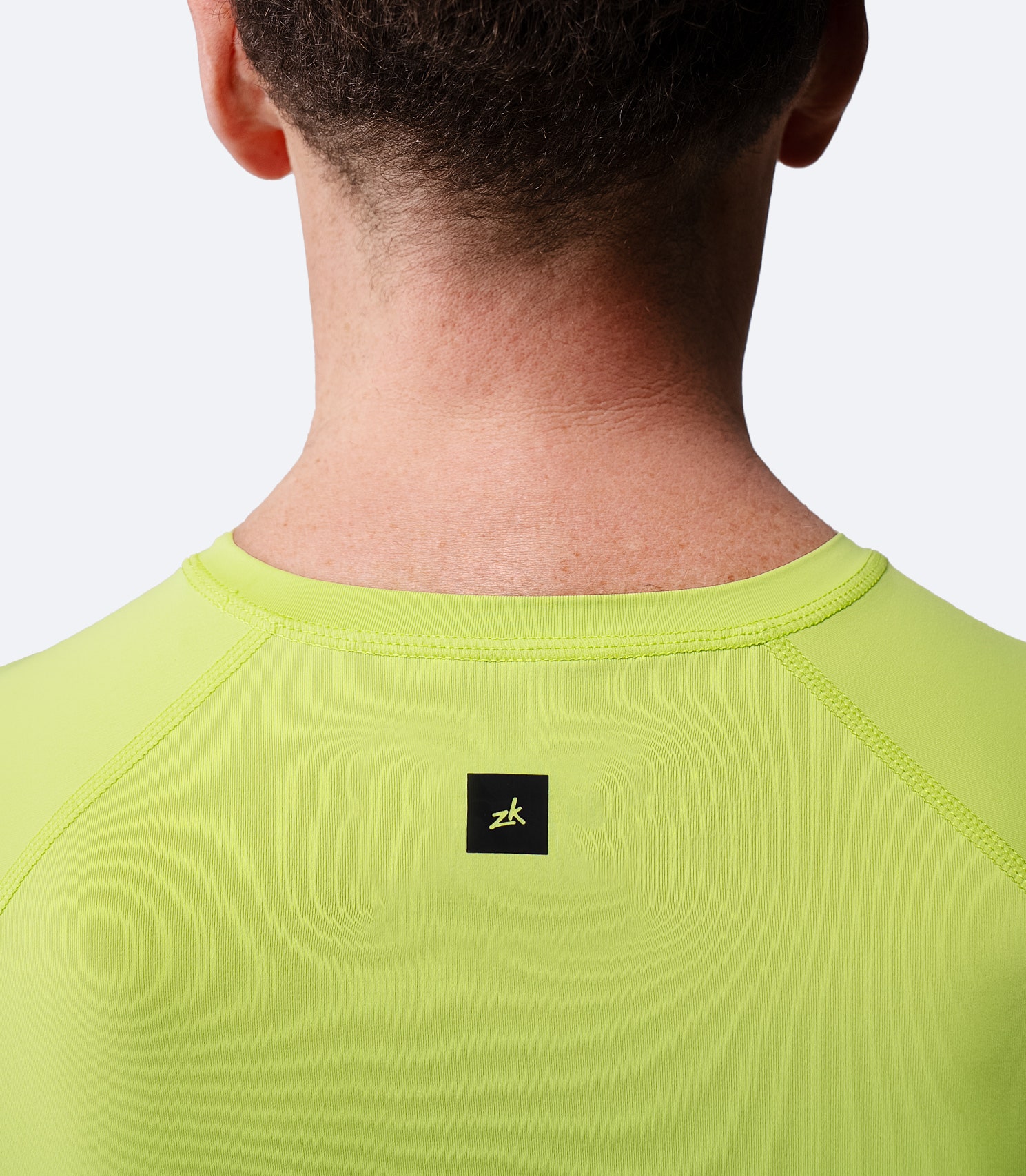 Close-up of collar and shoulder detail on Men’s Eco Spandex LT Baselayer Top in lime