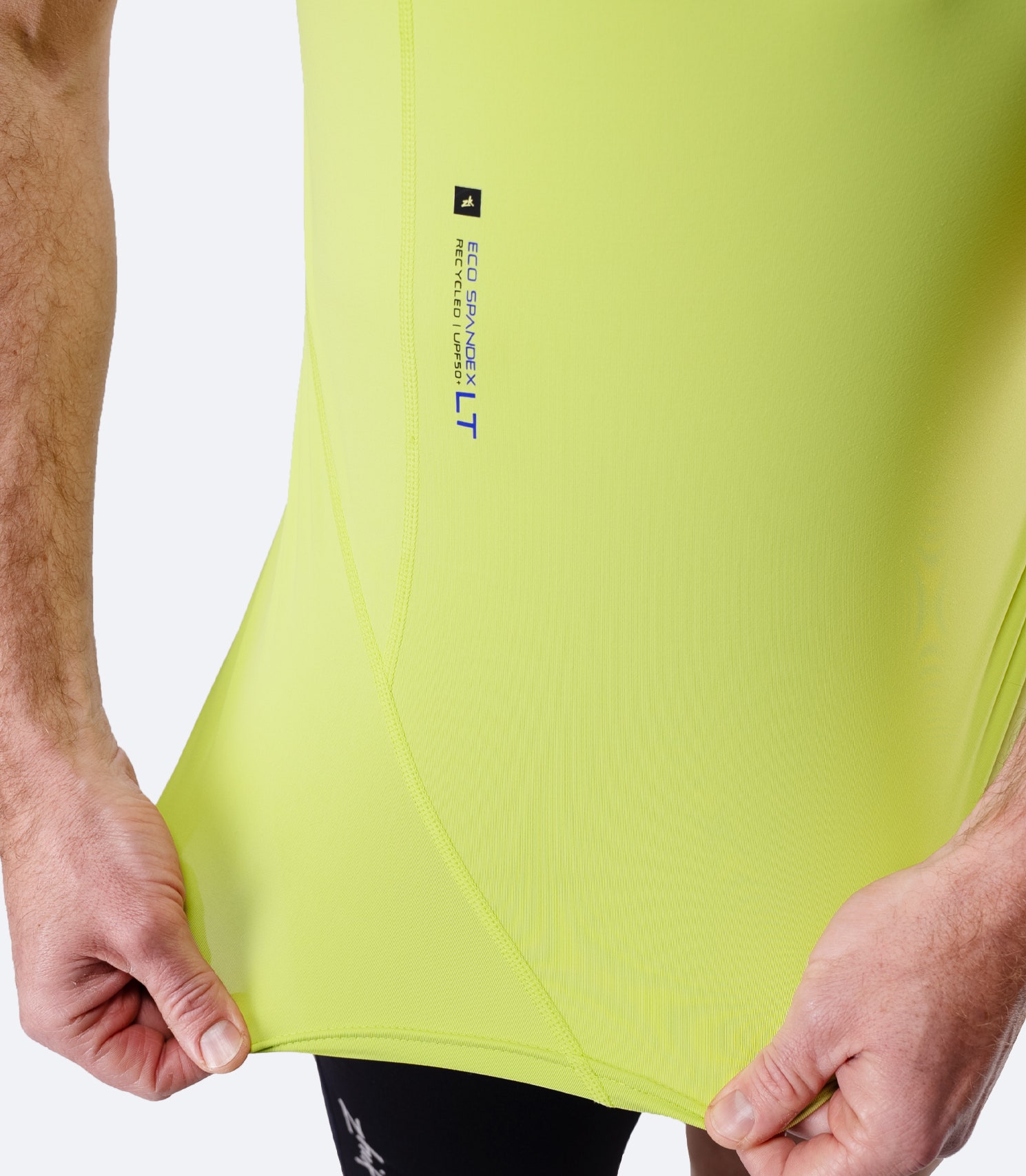 Close-up of hem label on Zhik Men’s Eco Spandex LT Short Sleeve Baselayer Top in lime
