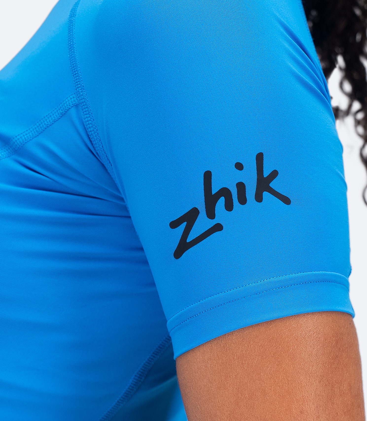 Cyan Zhik Women's Eco Spandex LT Baselayer arm closeup with visible Zhik logo and stretchy recycled fabric construction.