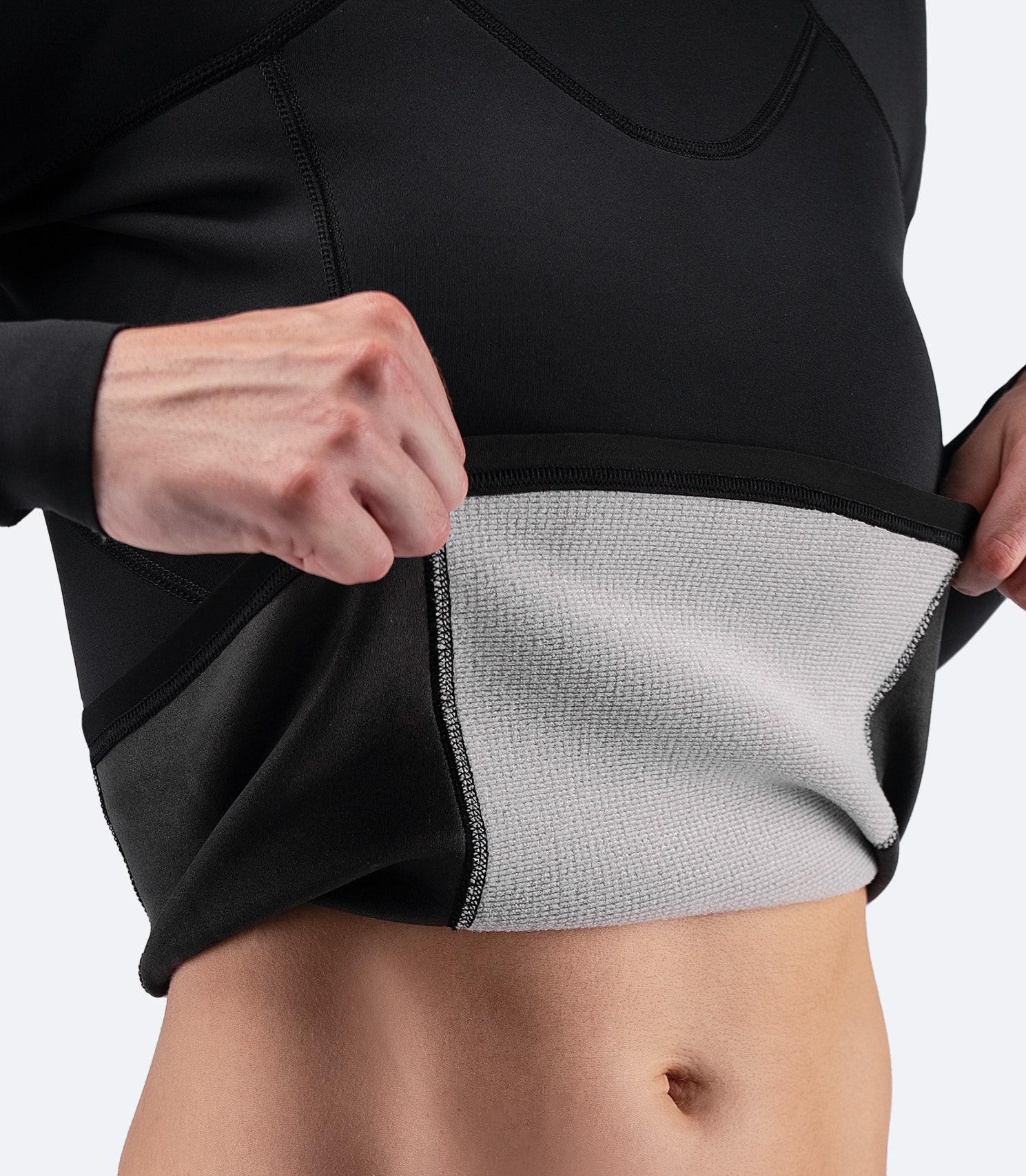 Close-up of Zhik Women's Microfleece Top with bottom lifted to reveal 1mm & 2mm Microfleece™ neoprene insulation for warmth and flexibility.