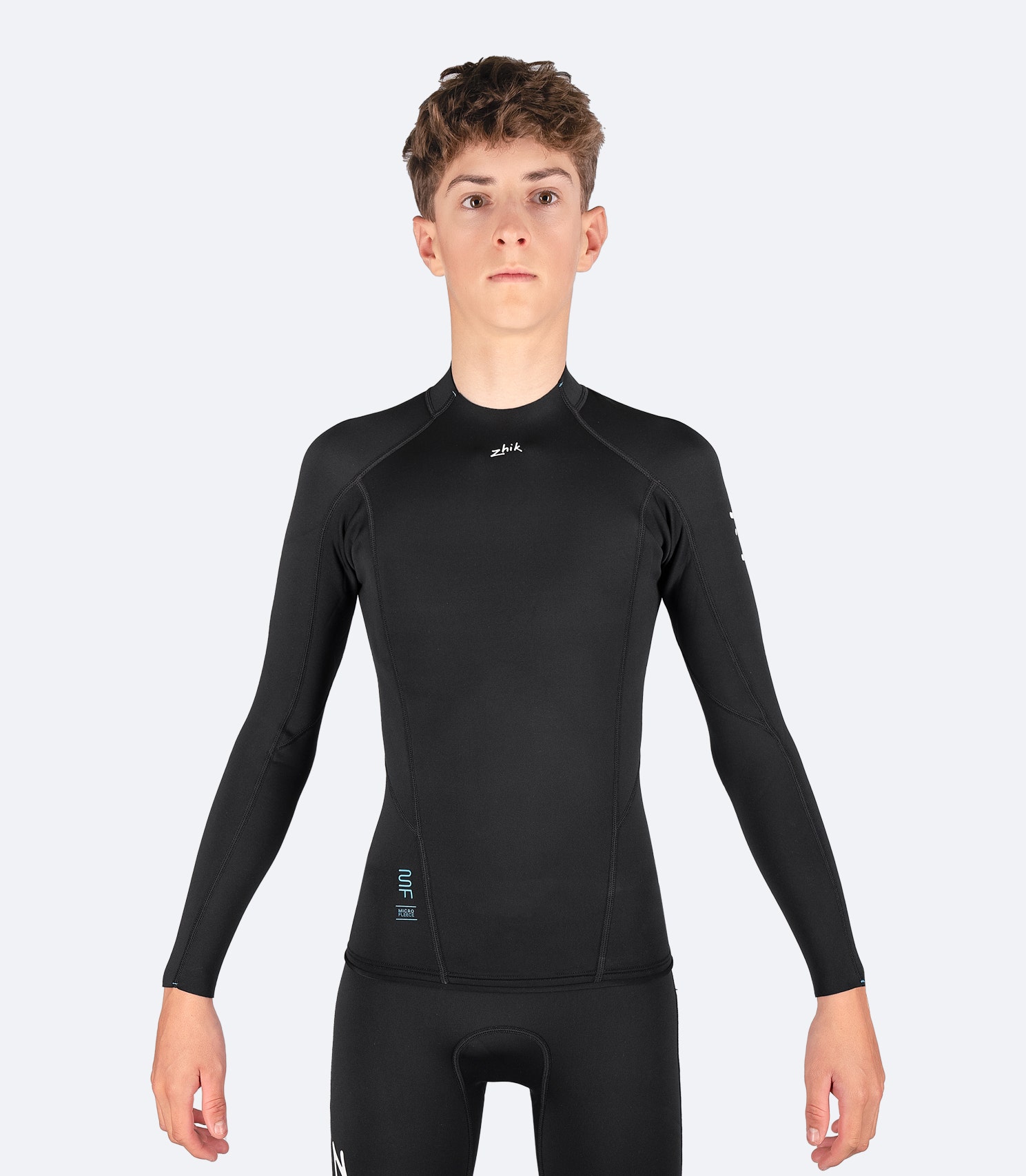 Front view of Zhik Youth Microfleece Top, featuring a mid-profile collar, shaped raw front, and flatlock seam construction for durability