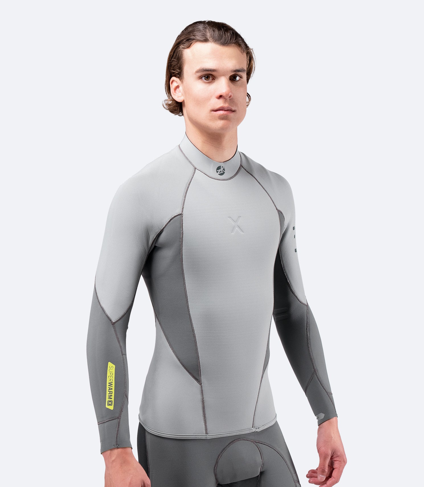 Model wearing Zhik Men's Superwarm X Top in grey, showcasing a 3D body-mapped fit and Hydrobase fleece lining for insulation.