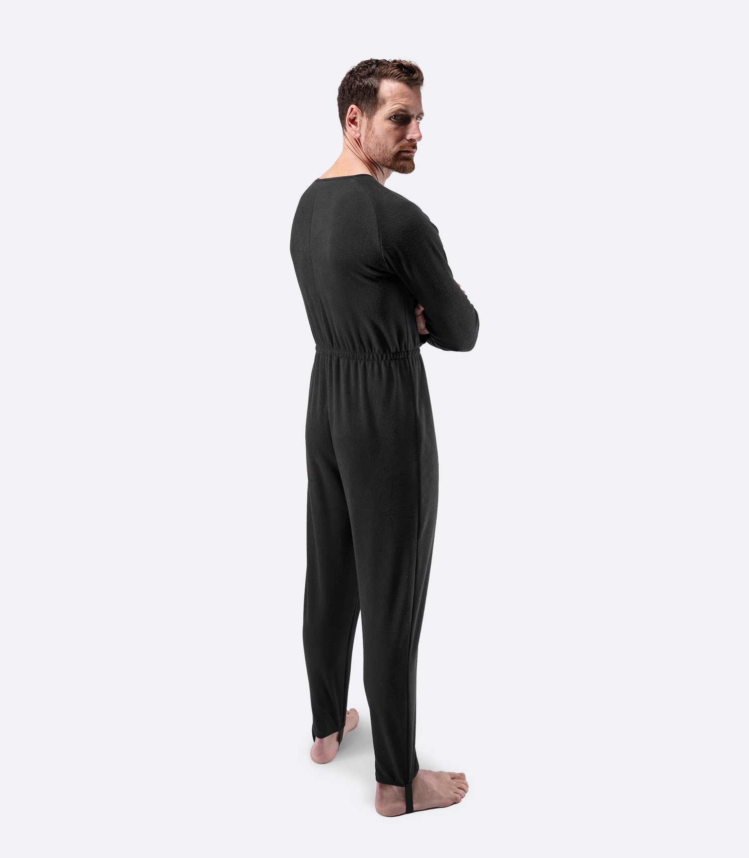 Side profile of male model wearing Zhik Drysuit Underfleece in black