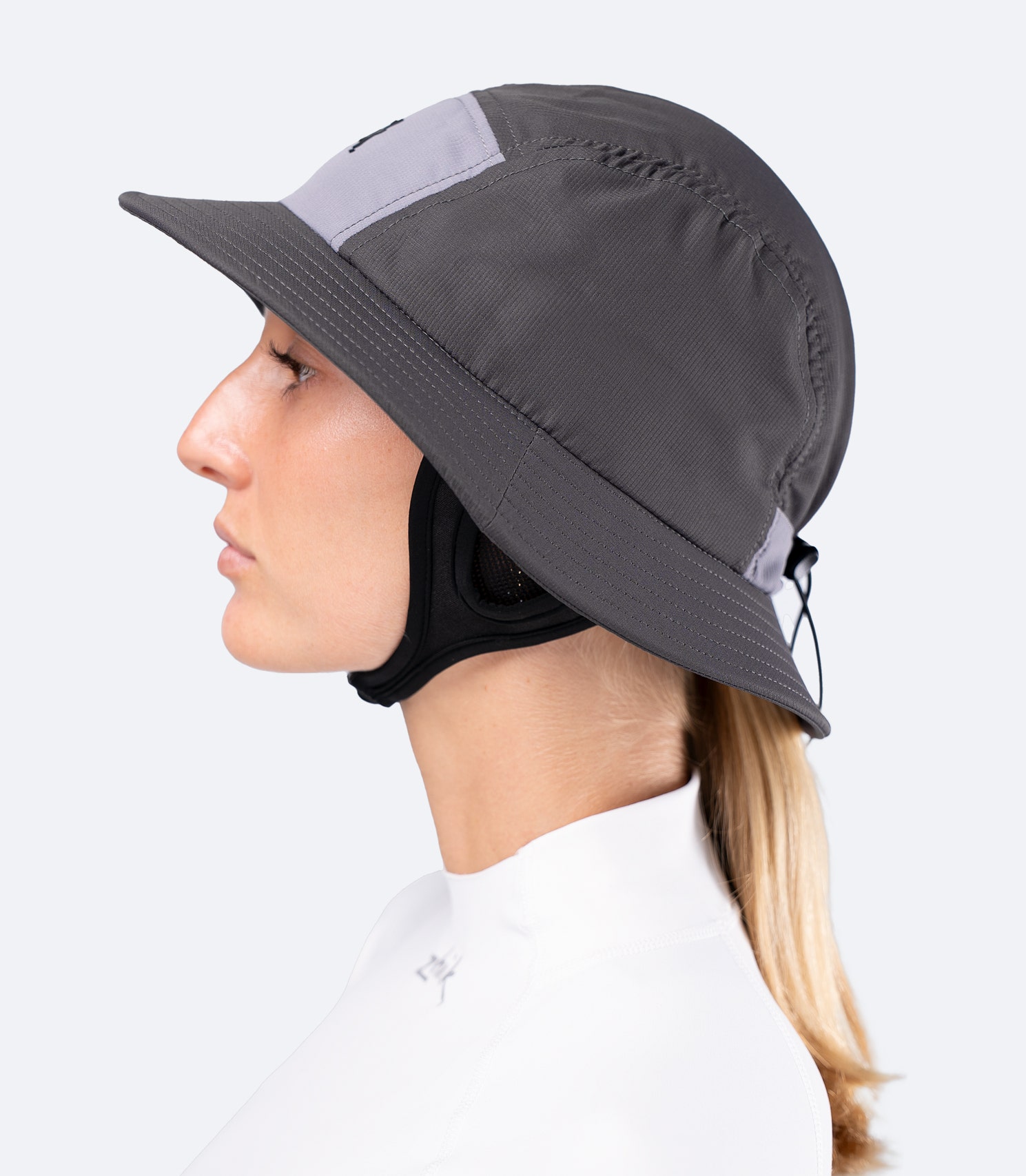 Side view of Zhik Bucket Hat in Slate on female, highlighting close fit, mesh ear panels and removable neoprene chin strap.