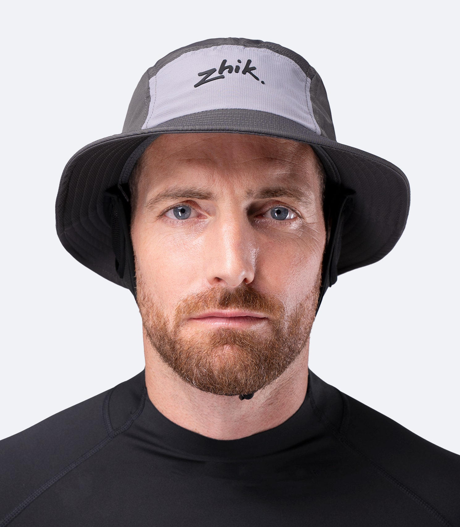 Front view of Zhik Bucket Hat in Slate on male, showing relaxed coastal style with structured brim and secure chin strap
