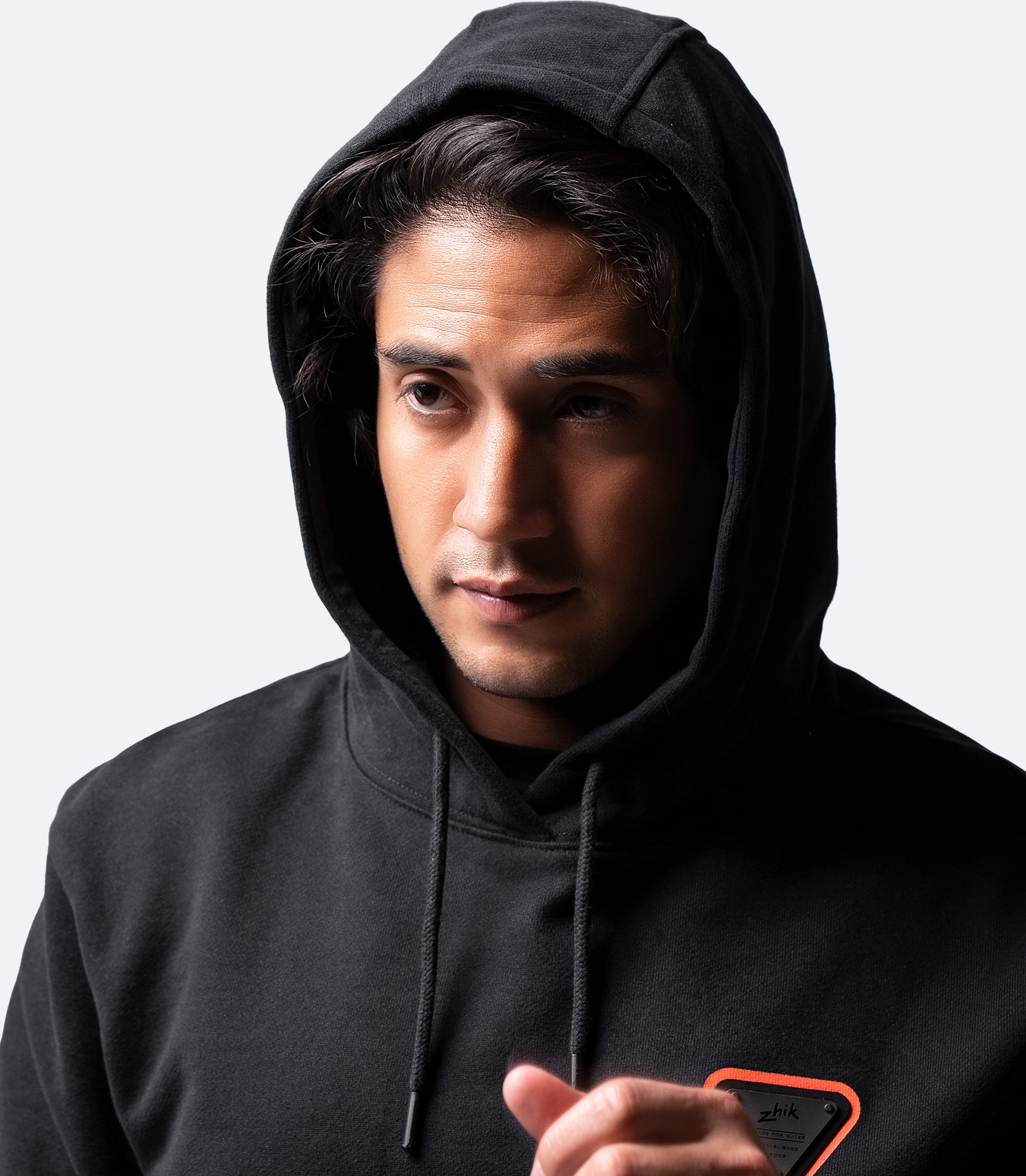 Nahaufnahme des Zhik Men’s Black Cotton Hoodie – weicher Baumwollstoff, Zhik-Logo-Detail und verstellbare Kapuze für Wärme.