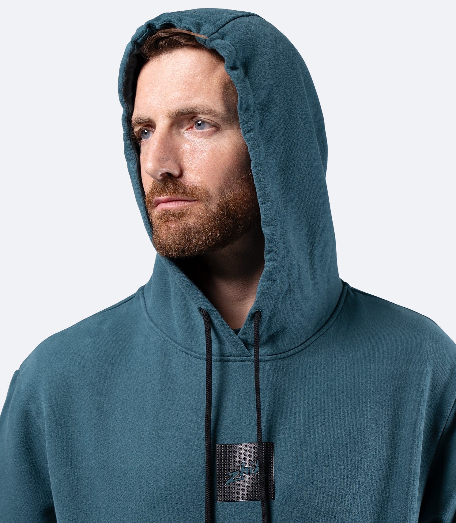 Front close-up of Deep Teal Zhik Men's Carbon Hoodie hood, with draw string adjustment for secure fit