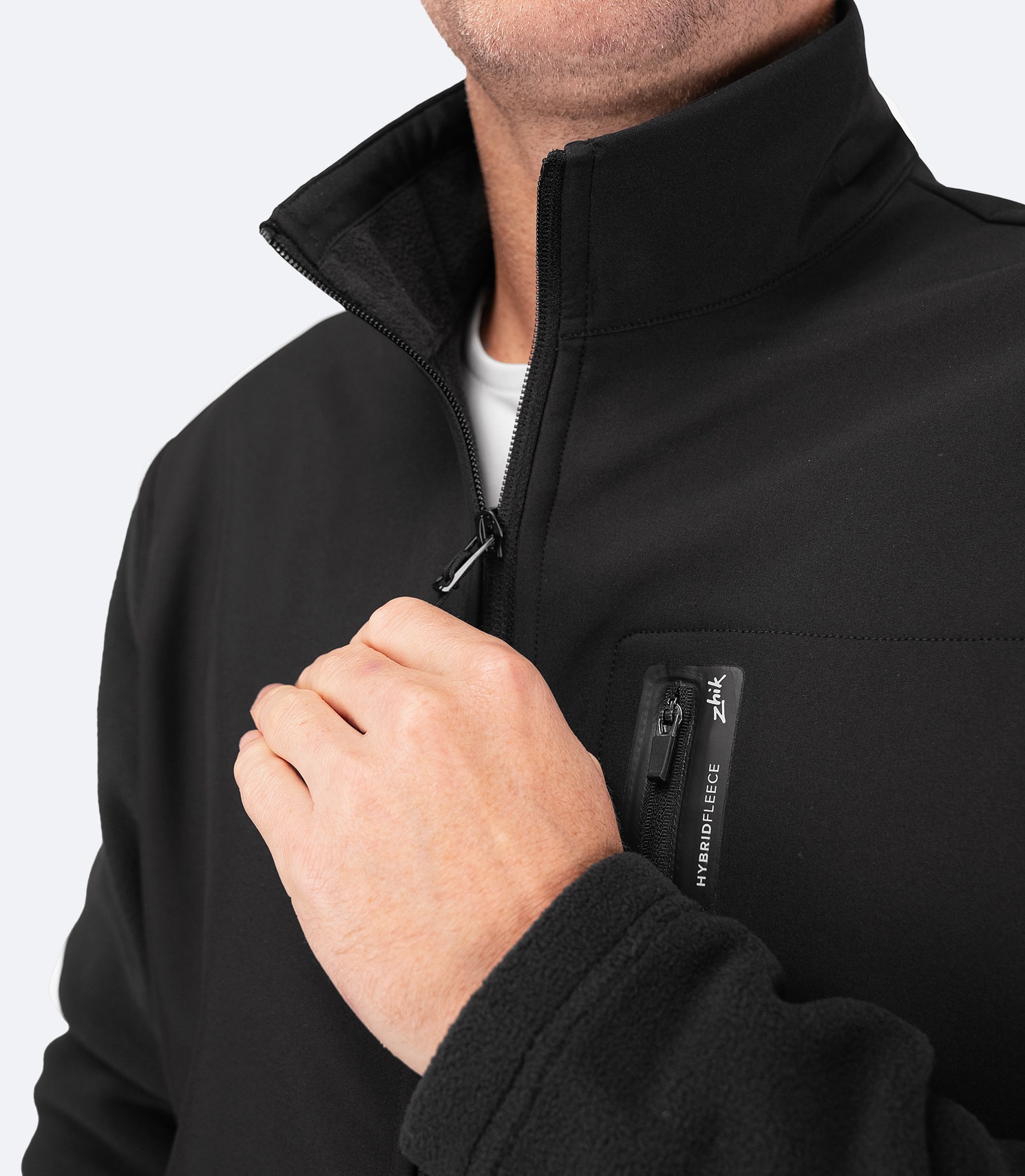 Mid-height collar on Zhik Men's Hybrid Fleece Jacket in black for wind protection, with softshell shoulder panels for durability