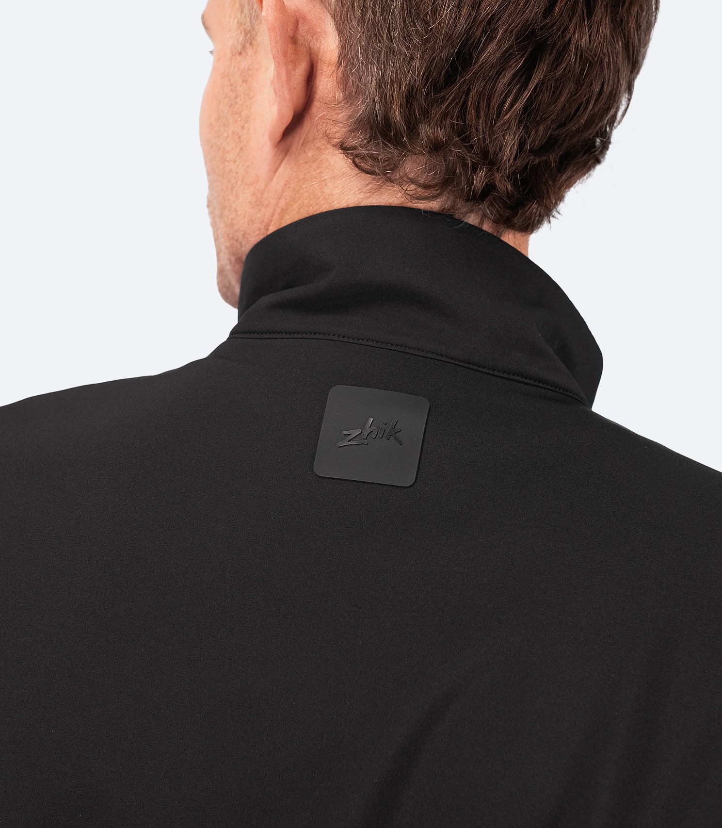 Mid-height collar on Zhik Men's Hybrid Fleece Jacket in black for wind protection, with softshell shoulder panels for durability