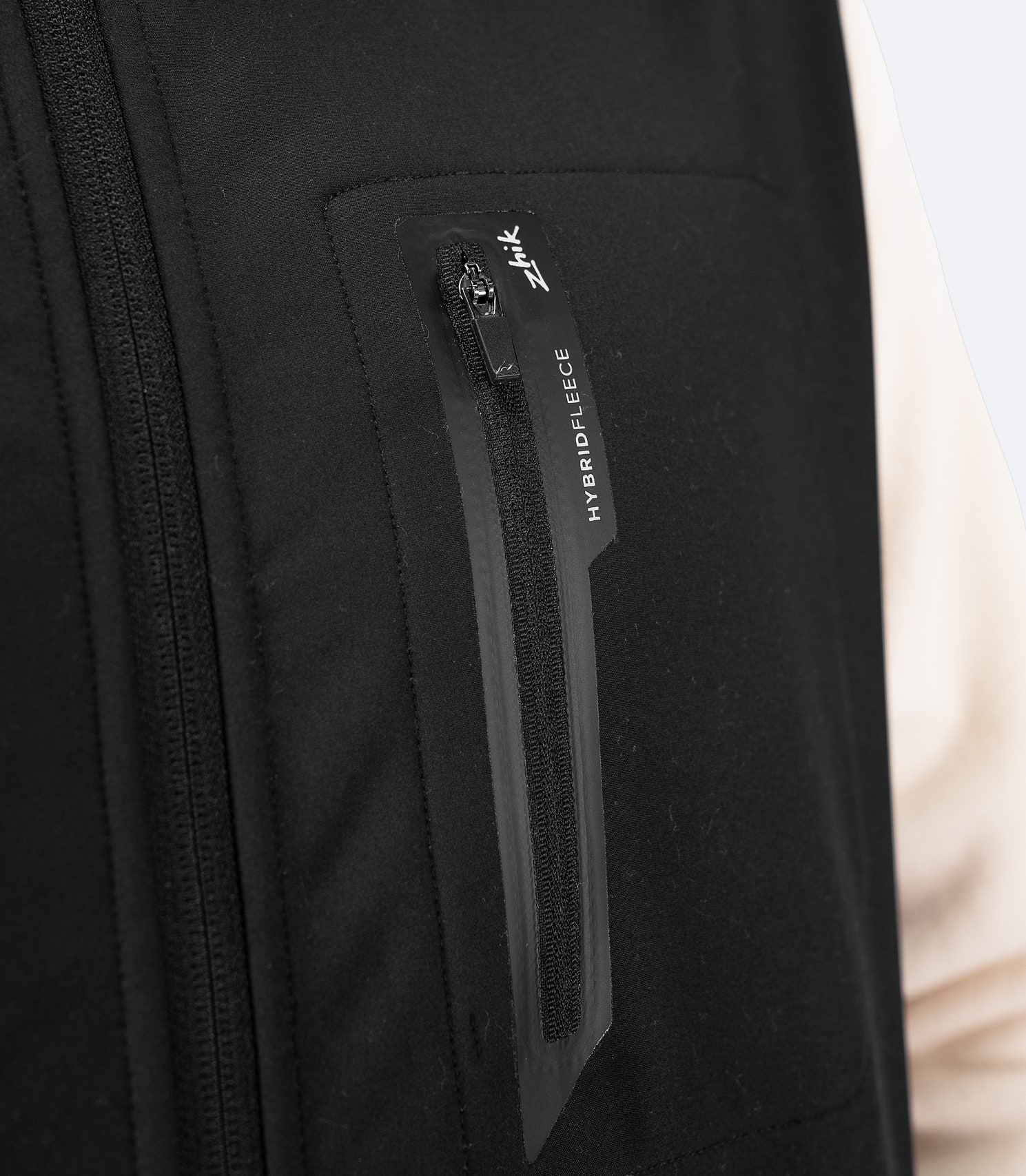 Zhik Men's Hybrid Fleece Jacket in chalk with an external chest pocket for easy access and secure storage while sailing or outdoors.