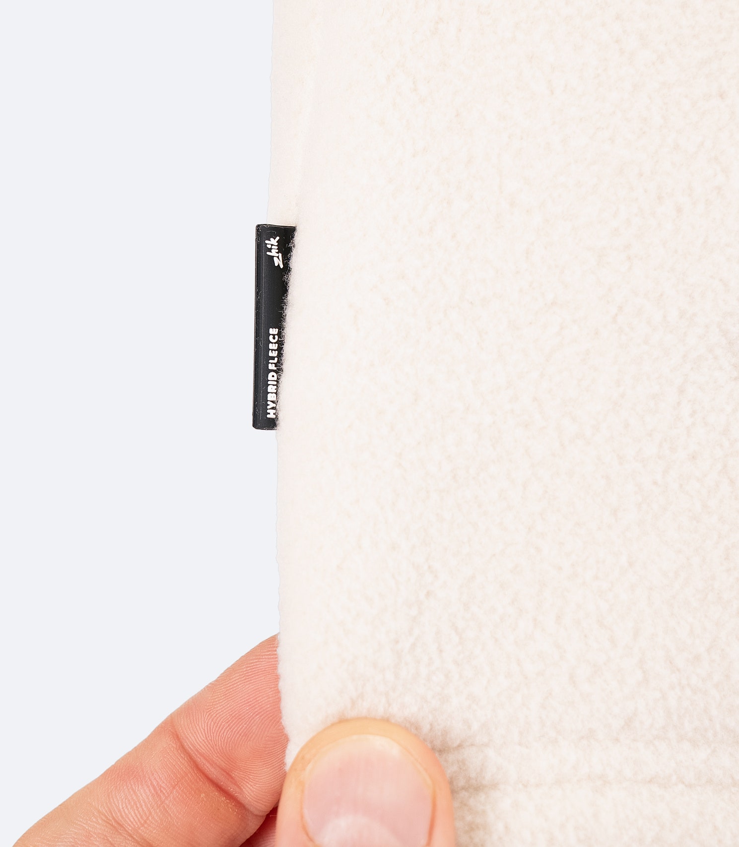 Close-up of chalk Zhik Men's Hybrid Fleece Jacket fabric, showing soft recycled fleece and windproof, water-repellent softshell panel
