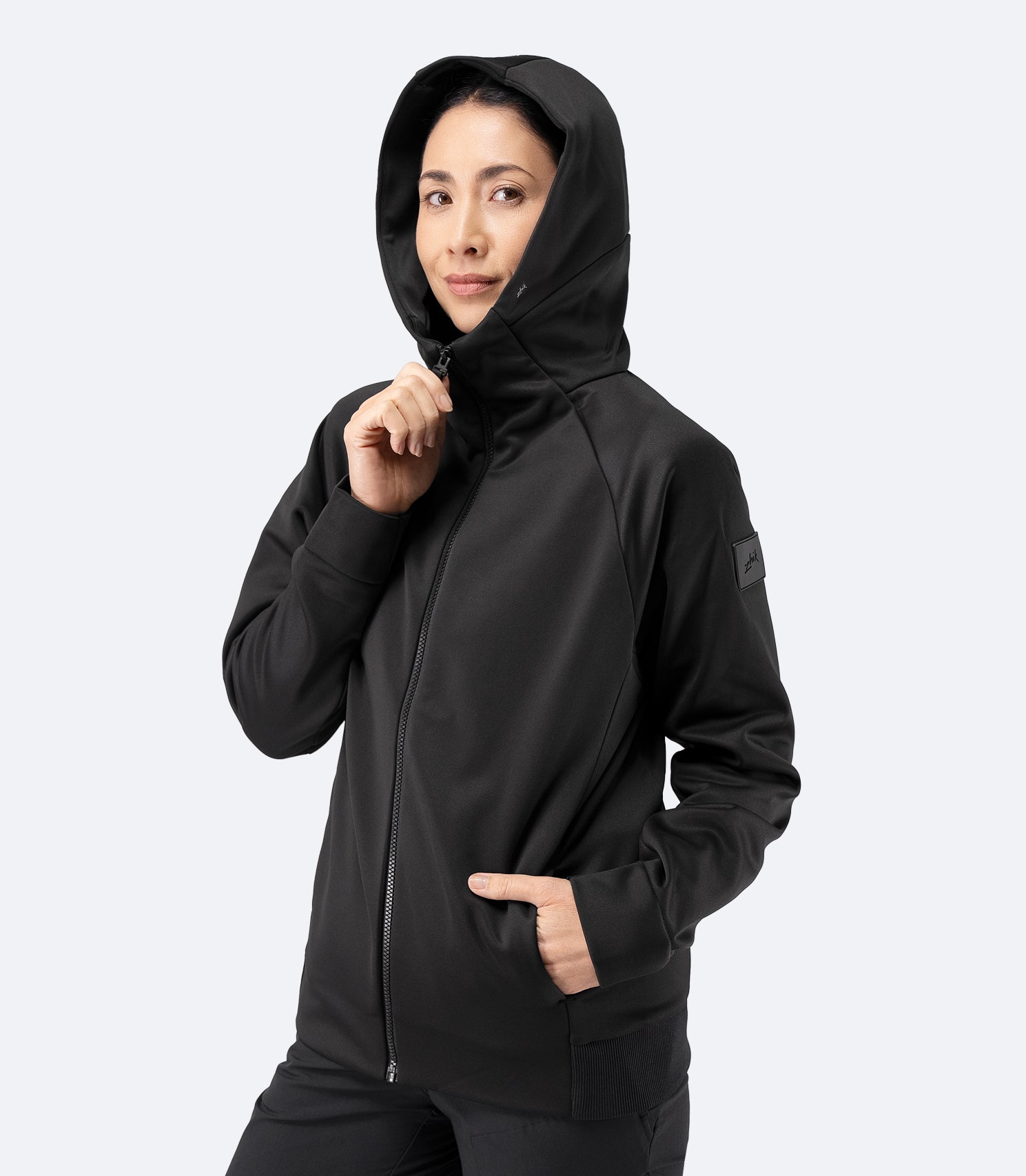 Front view of Zhik Women’s Thermo TechFleece Hooded Jacket in black with hood up