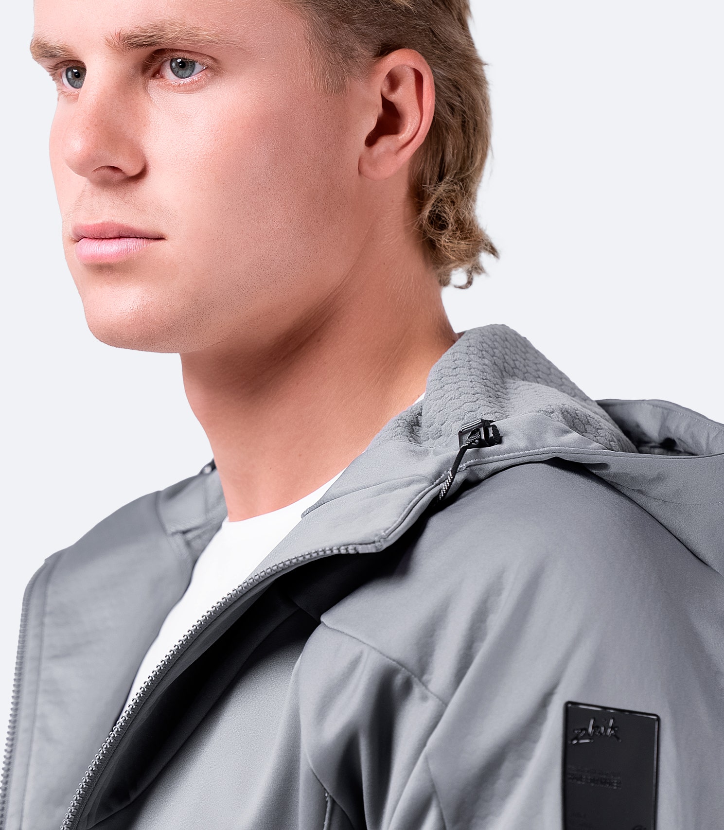 Close-up of platinum Zhik Men's Tech Hoodie, highlighting shoulder details and ergonomic hood-down design.