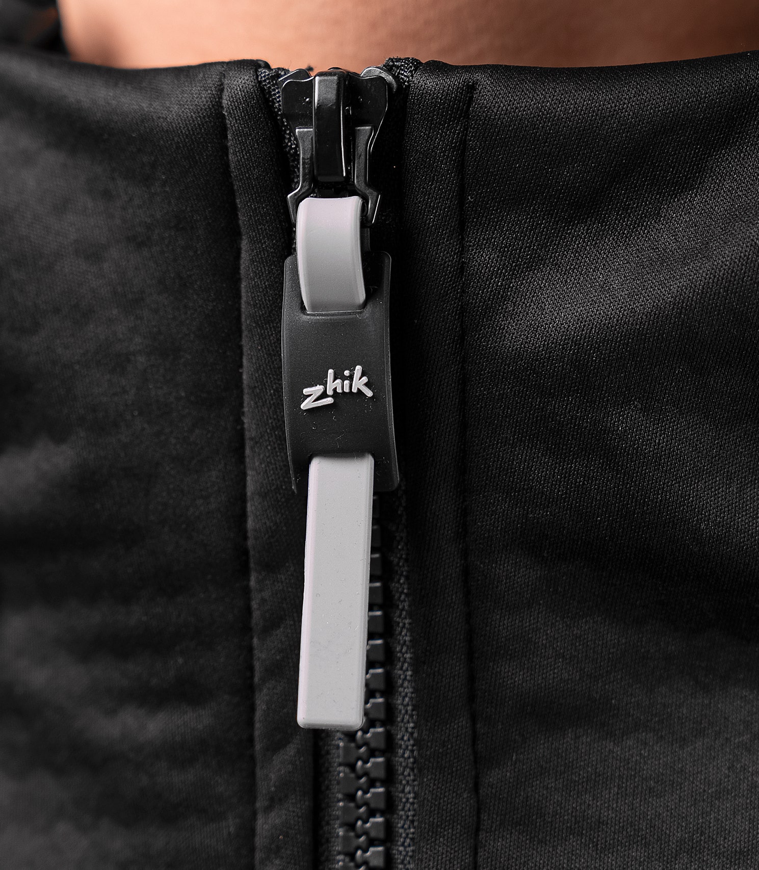 Close-up of the zipper on the black Zhik Women's Tech Hoodie, highlighting secure fastening and durable waterproof design.