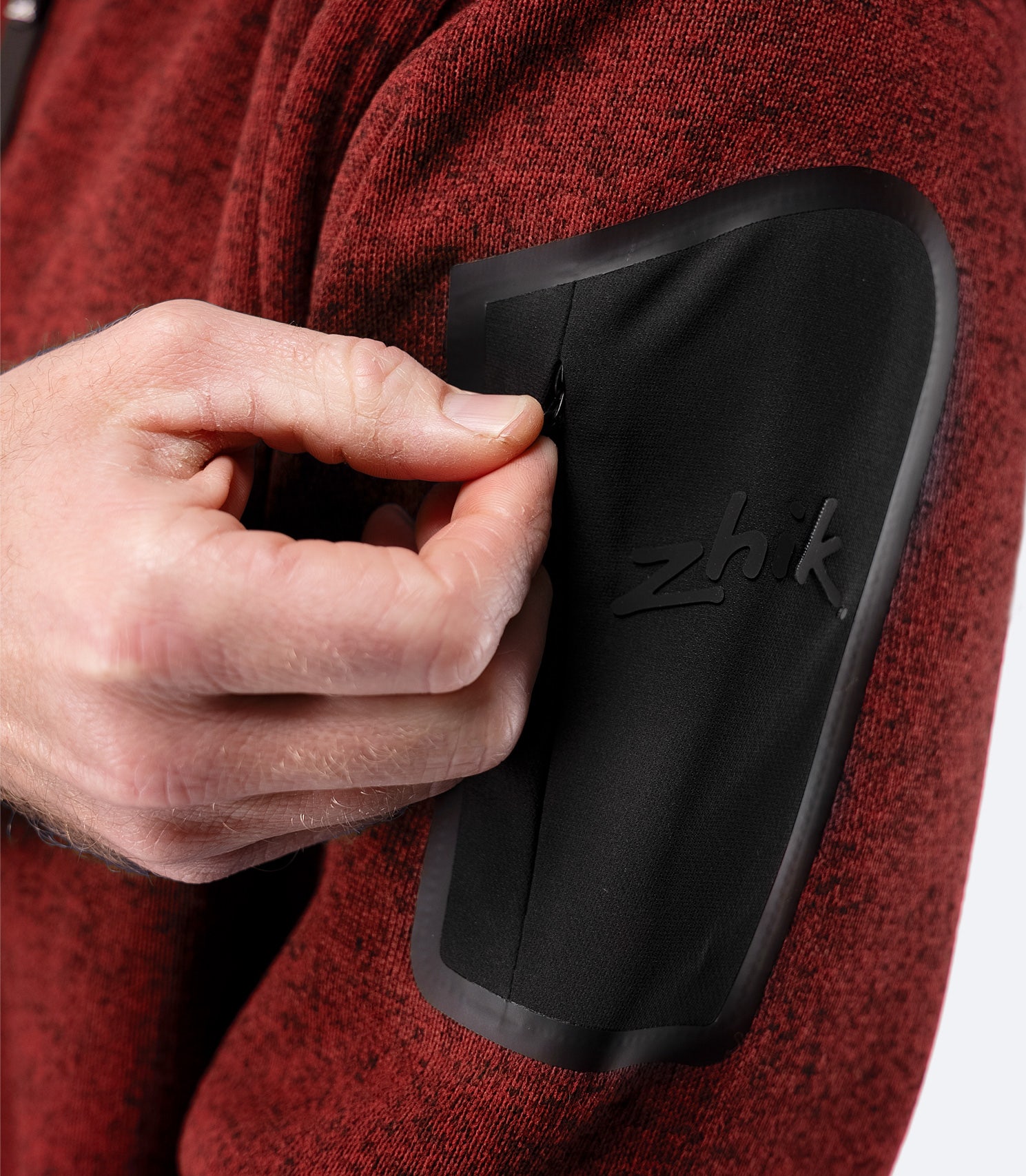 Close-up of zippered arm pocket on Zhik Men’s Knit Fleece Jacket in garnet marle