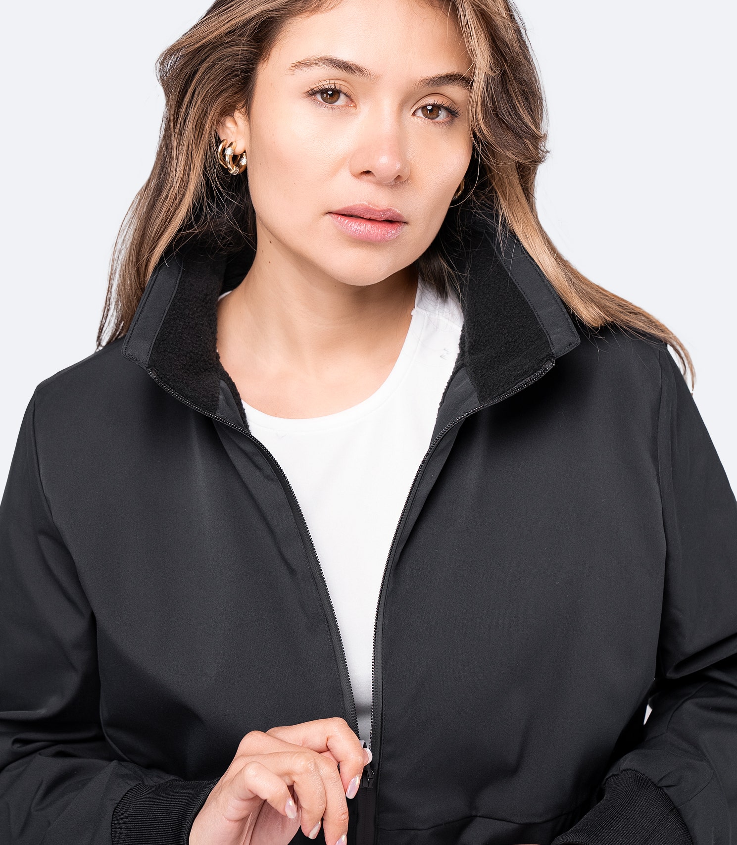 Close-up of black Women's Flight Jacket collar and wrist cuffs, featuring fleece lining and smooth twill fabric.