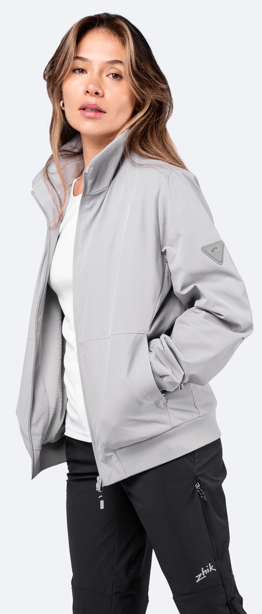 Side view of platinum Women's Flight Jacket worn open, showcasing breathable sprayproof fabric and warm fleece lining.