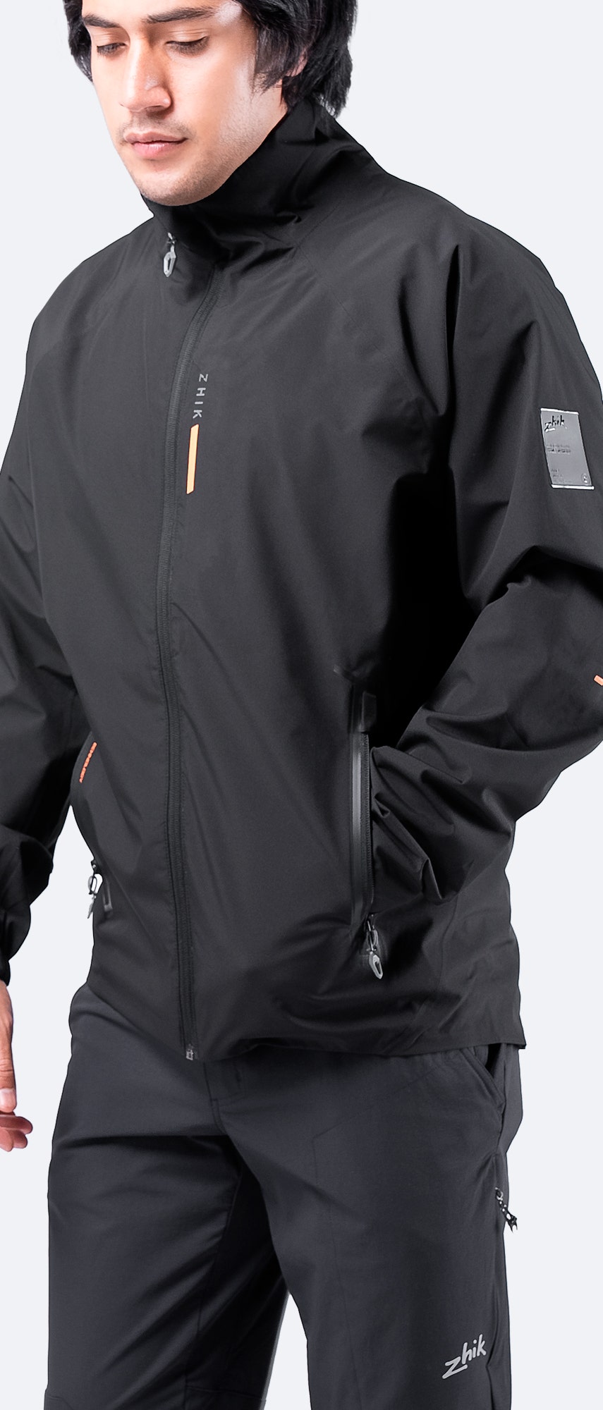 Side view of Zhik Men's INS100™ Jacket in Black, showcasing lightweight, breathable construction and zippered side pockets.