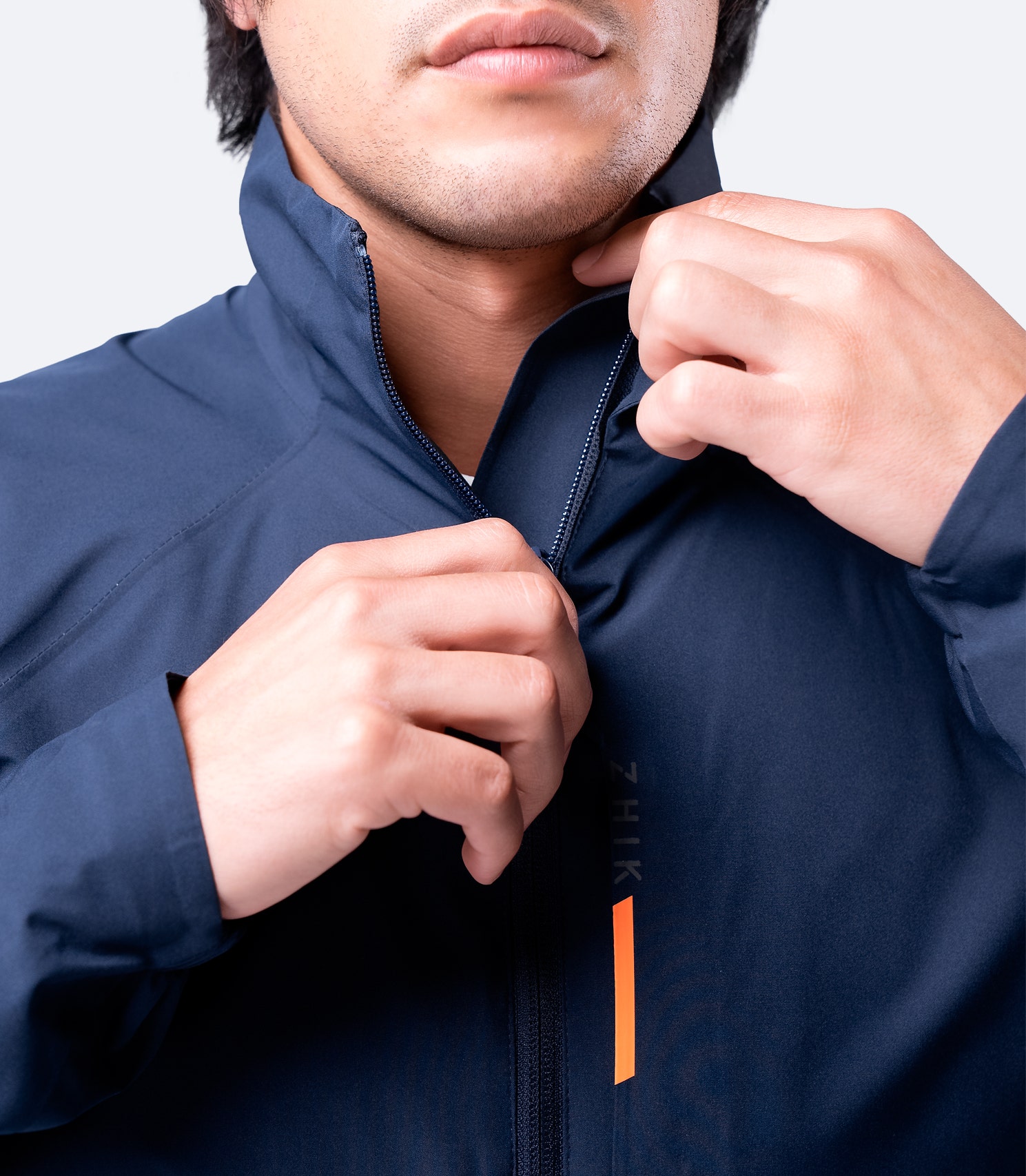 Close-up of Zhik Men's INS100™ Jacket in Navy, showing high collar, smooth zip closure, and waterproof fabric with durable water repellency