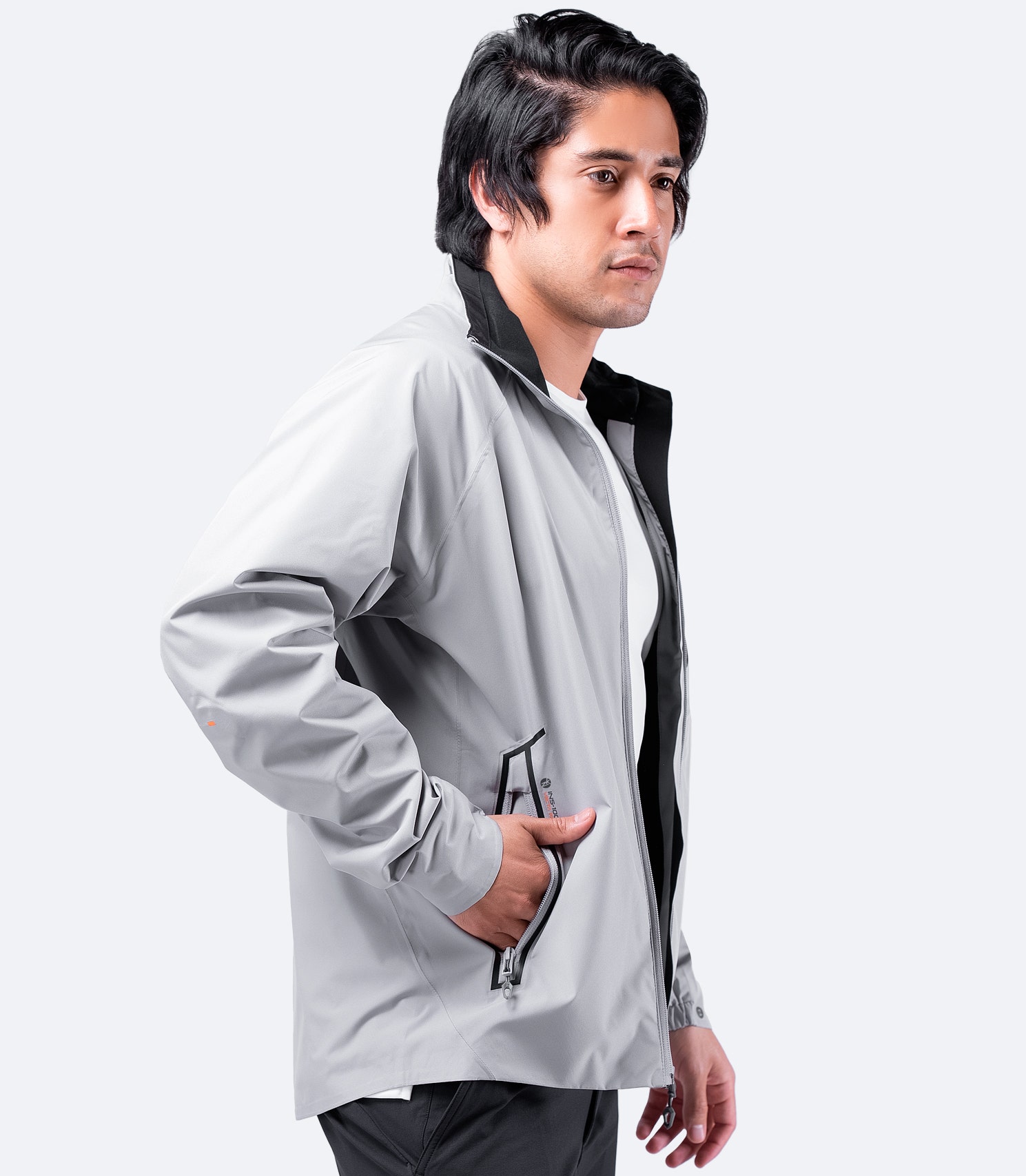 Side view of Zhik Men's INS100™ Jacket in Platinum with open zipper, showcasing lightweight, breathable construction and zippered side pockets