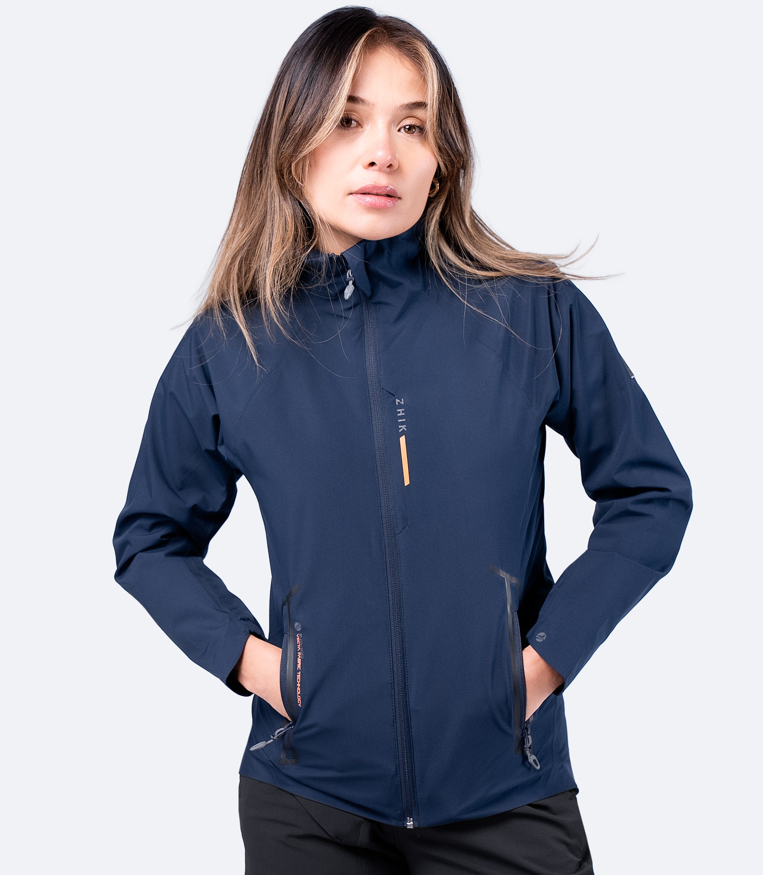 Zhik Women's Navy INS100™ Jacket, zipped up to showcase its streamlined fit, breathable waterproof fabric, and sailing-ready design.