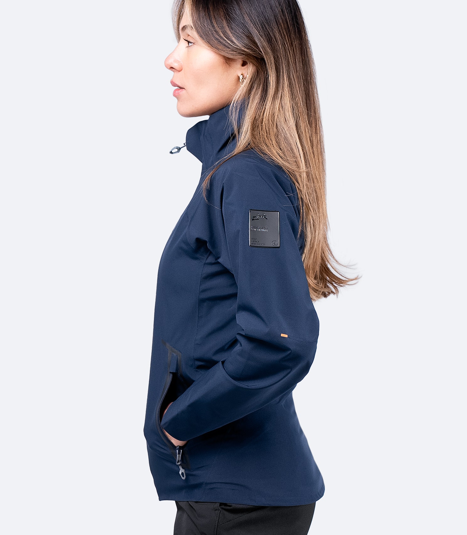 Zhik Women's Navy INS100™ Jacket, side view highlighting zippered pocket and pre-formed cuffs for unrestricted movement.