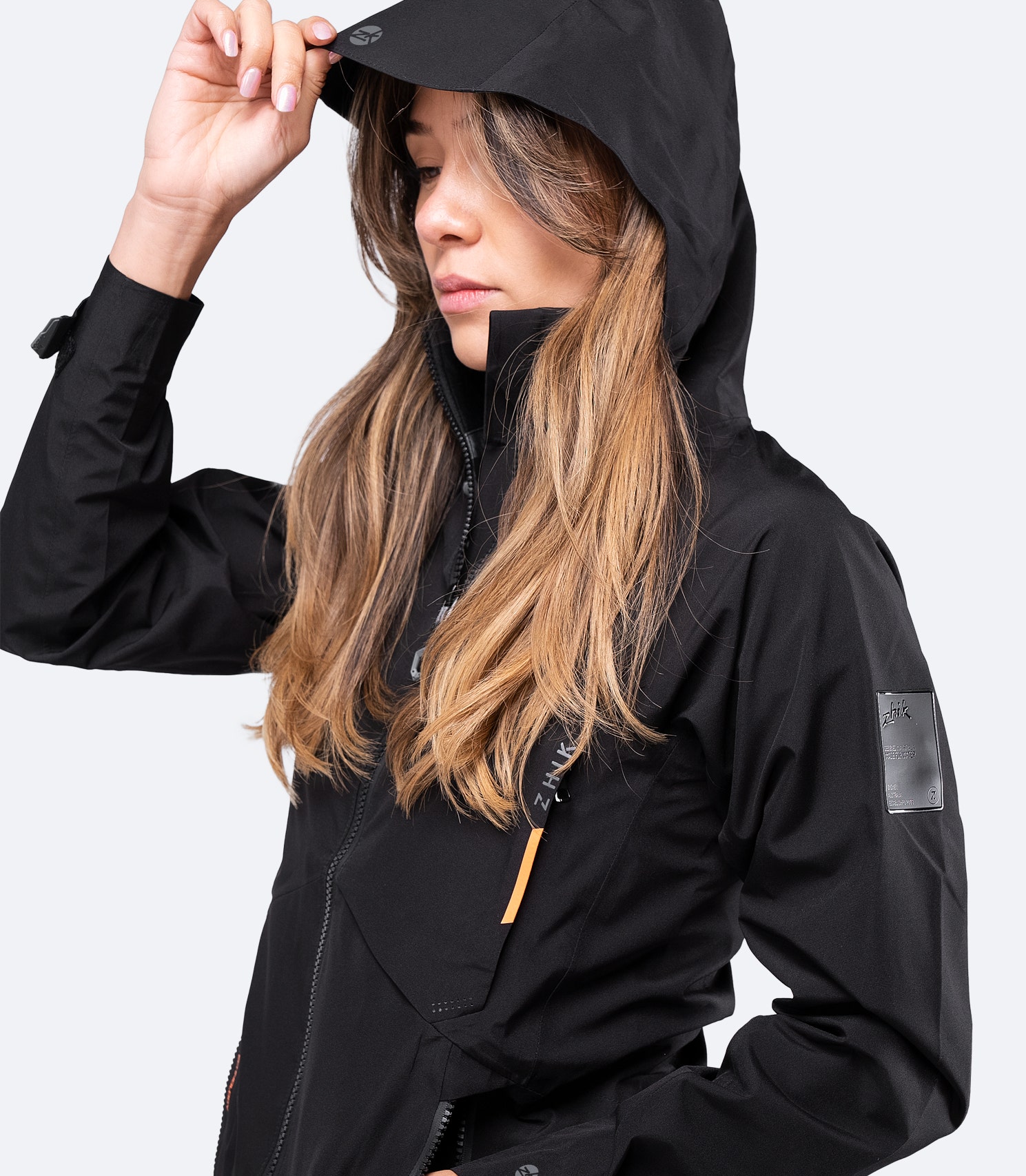 Side angle view of Zhik Women's Black INS200™ Jacket with hood on, highlighting breathable waterproof protection for inshore sailing.