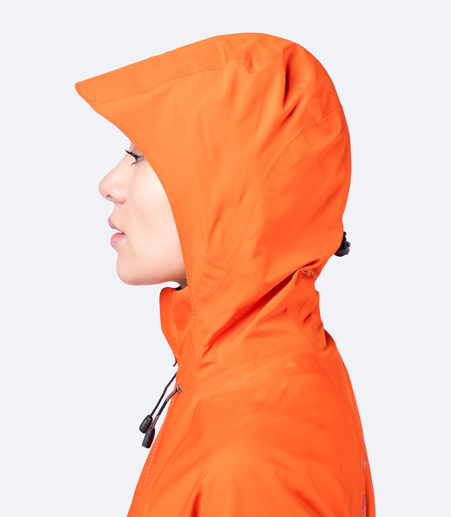 Side profile of Zhik Women's Flame Red INS200 Jacket with hood up, showing high collar, adjustable fit, and waterproof protection