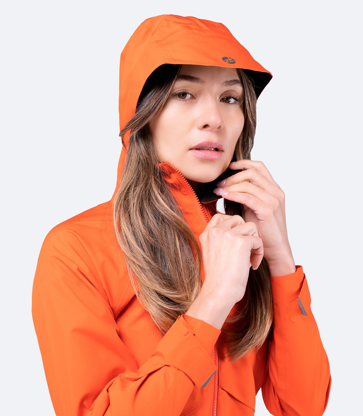 Zhik Women's Flame Red INS200 Jacket with hood up and high collar zipped, showcasing waterproof protection and ergonomic fit